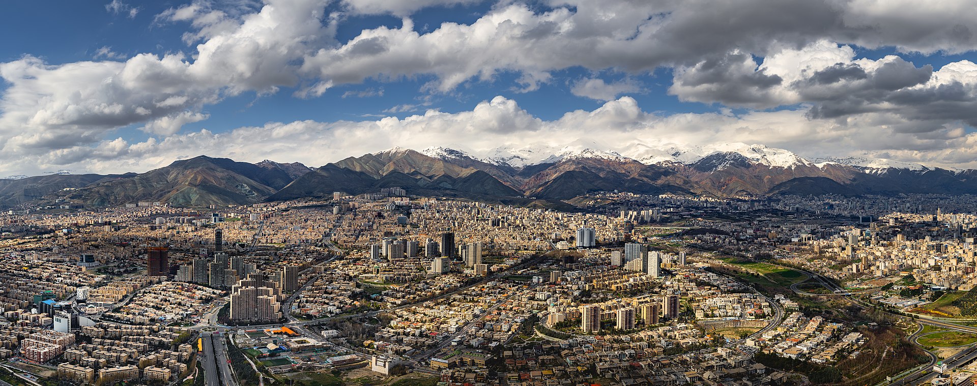 Aerial view of Tehran sprawling beneath the Alborz Mountains - the Iranian capital where Mojtaba Khamenei now holds supreme authority over the Islamic Republic during wartime. Photo: Wikimedia Commons / CC BY-SA 4.0