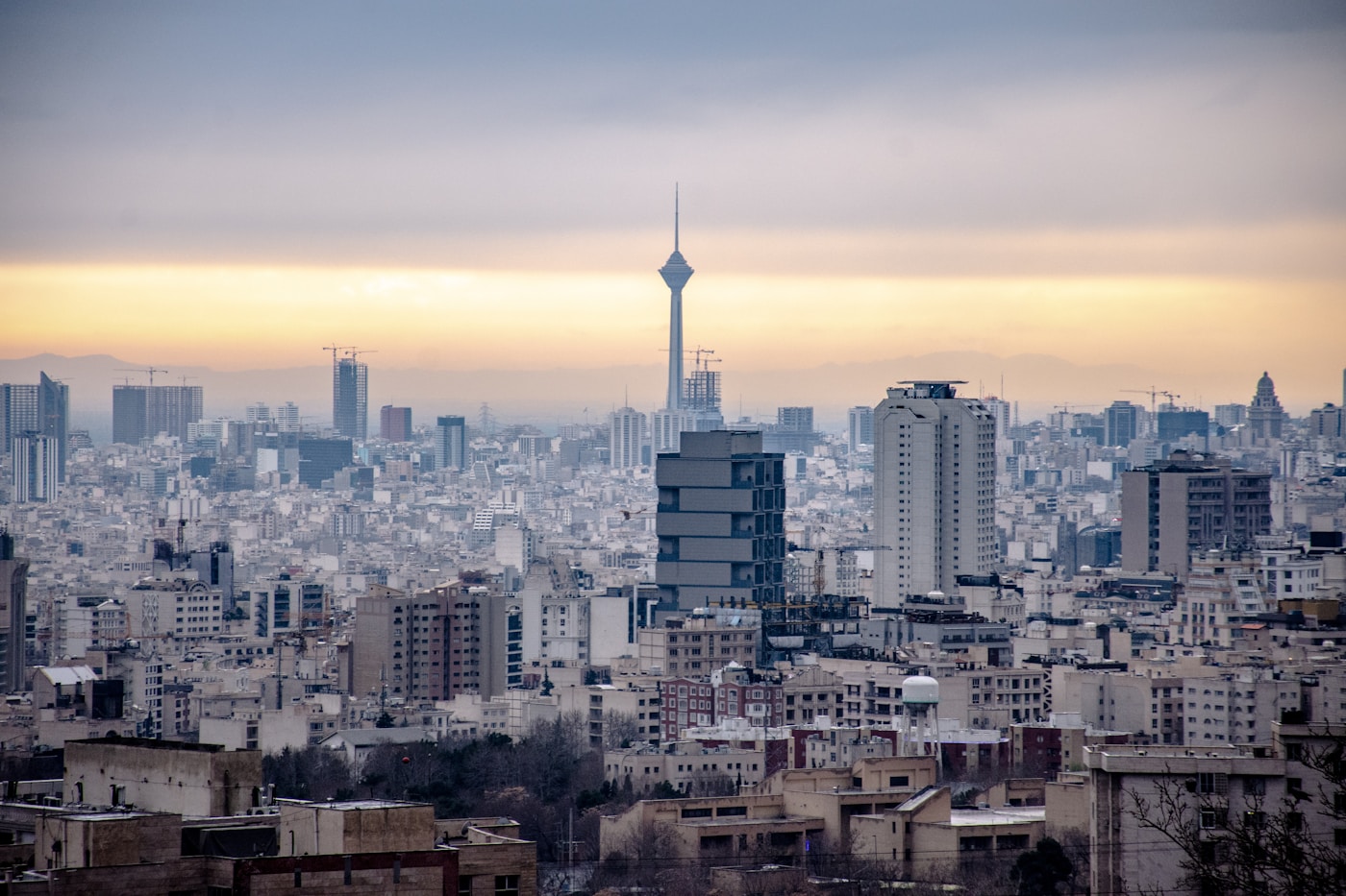 Tehran skyline showing the Milad Tower and dense urban landscape, with millions of residents facing daily air raid alerts during the 2026 Iran war