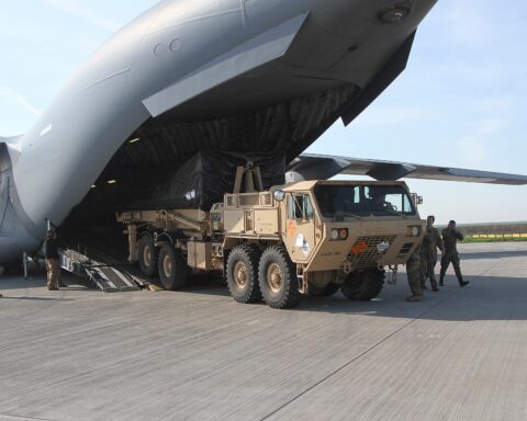 A THAAD missile defense launcher being offloaded from a U.S. Air Force C-17 Globemaster III transport aircraft, representing the advanced air defense systems deployed to protect Gulf states from Iranian missile attacks