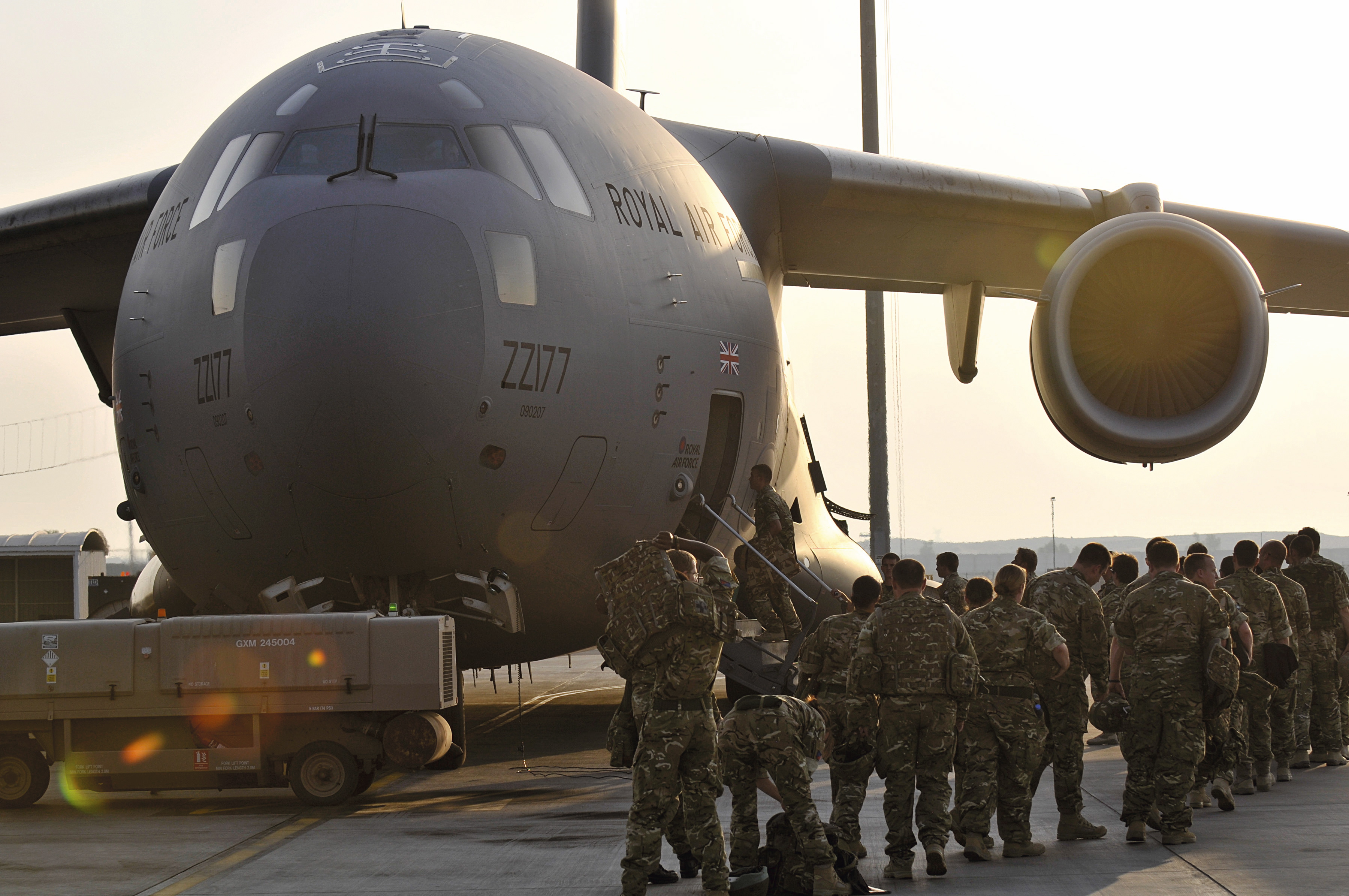 Troops board a C-17 Globemaster III military transport aircraft for deployment