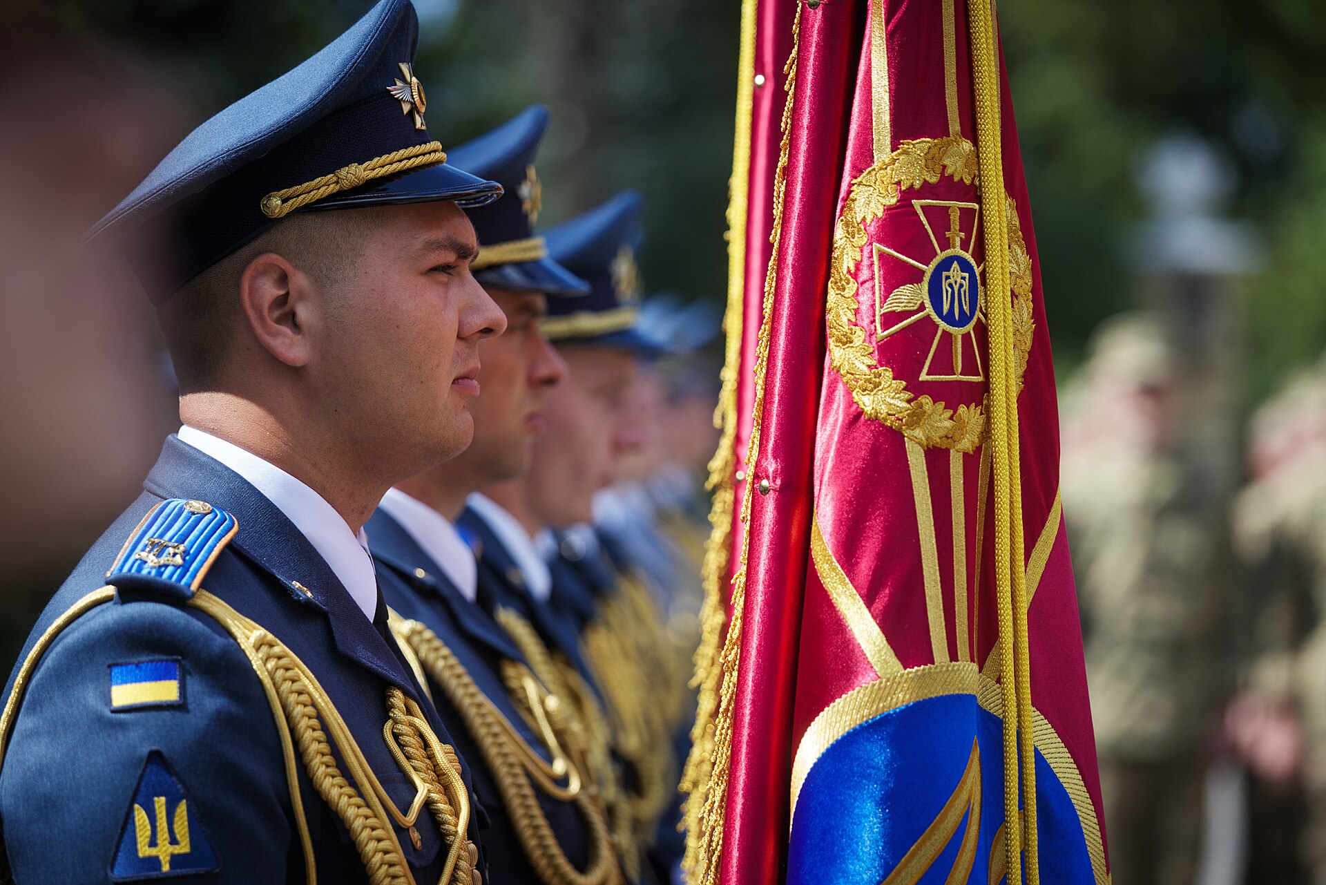 Ukrainian Air Force officers in ceremonial dress uniform stand at attention beside military standards, representing the expertise Ukraine brings to its defense cooperation deal with Saudi Arabia.