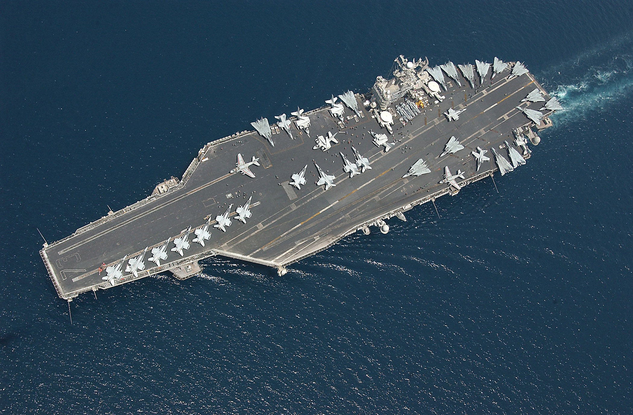 USS George Washington aircraft carrier with fighter jets on deck operating in the Arabian Gulf, representing US military commitment to the Middle East