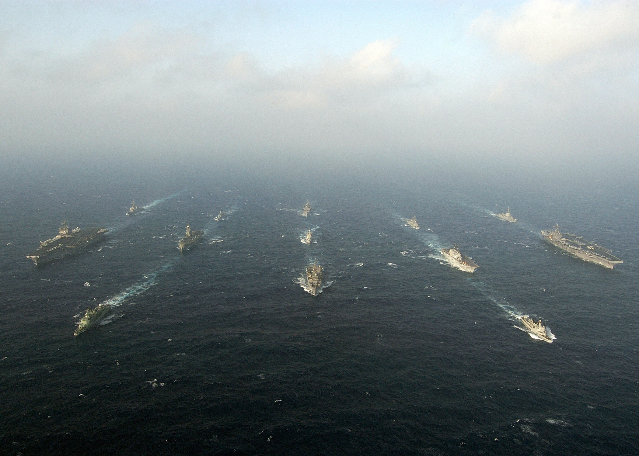 US Navy carrier strike group fleet formation with multiple warships and aircraft carriers steaming in the Atlantic Ocean