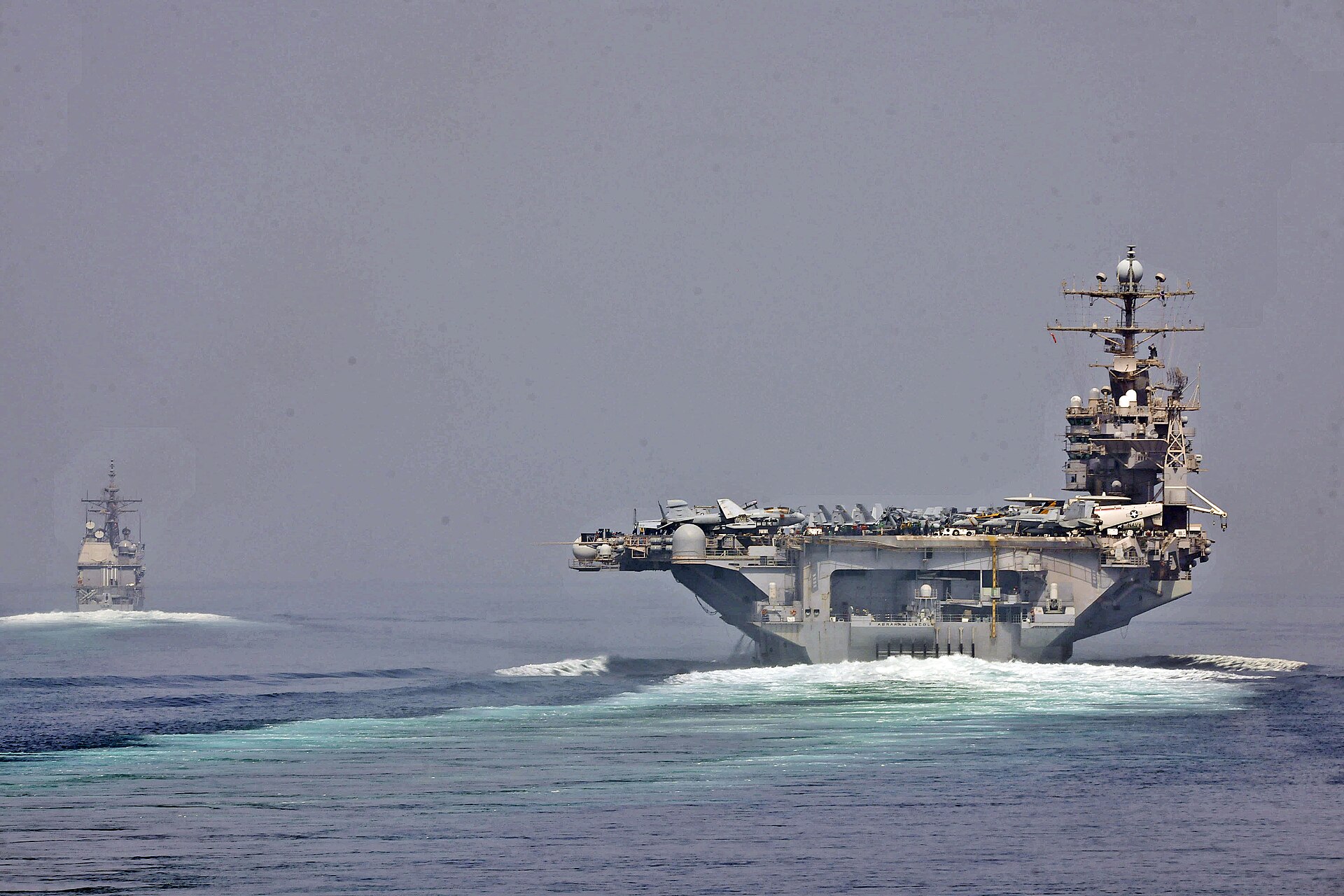 U.S. Navy aircraft carrier and guided-missile cruiser transit the Strait of Hormuz, the narrow waterway between Iran and Oman that handles 20 percent of global oil trade. Photo: U.S. Navy / Public Domain