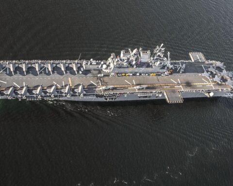 Aerial view of USS Tripoli (LHA-7) with 20 F-35B Lightning II stealth fighters on the flight deck, the amphibious assault ship now deploying to the Middle East. Photo: US Navy / Public Domain