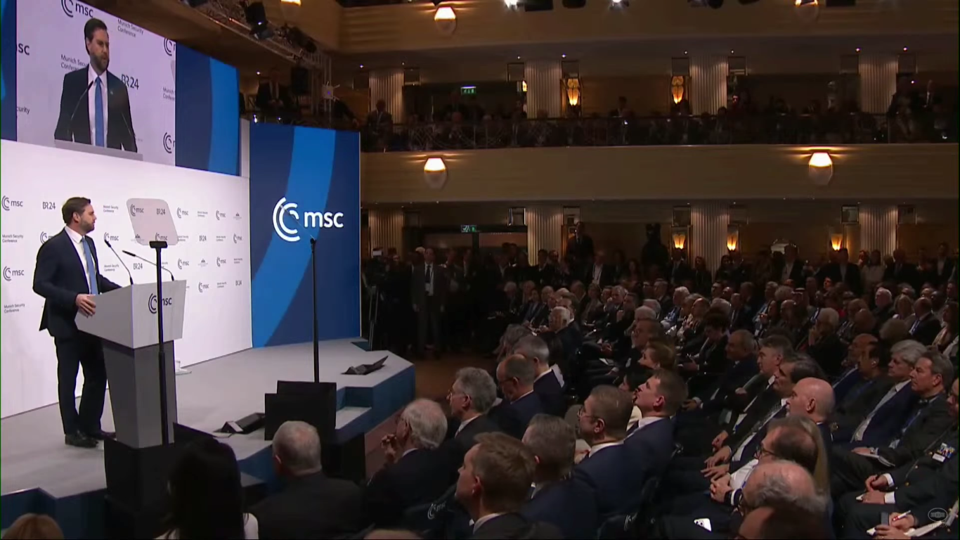 U.S. Vice President JD Vance delivers remarks at the Munich Security Conference podium before a packed audience of world leaders and diplomats
