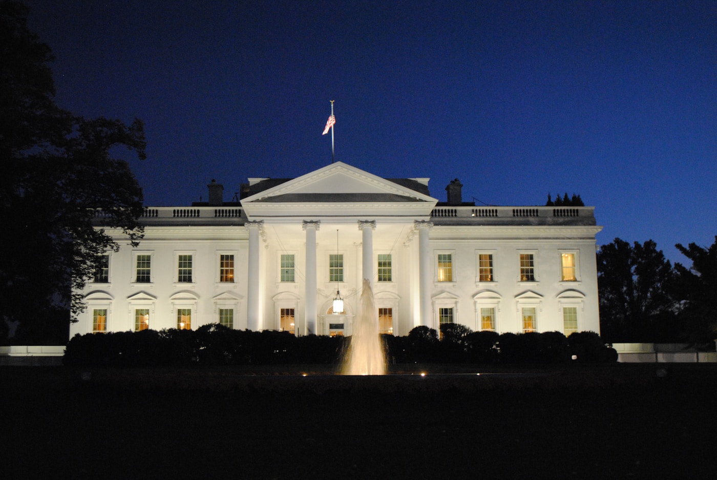 The White House illuminated at night, symbolizing US diplomatic negotiations with Iran on ending the Gulf war