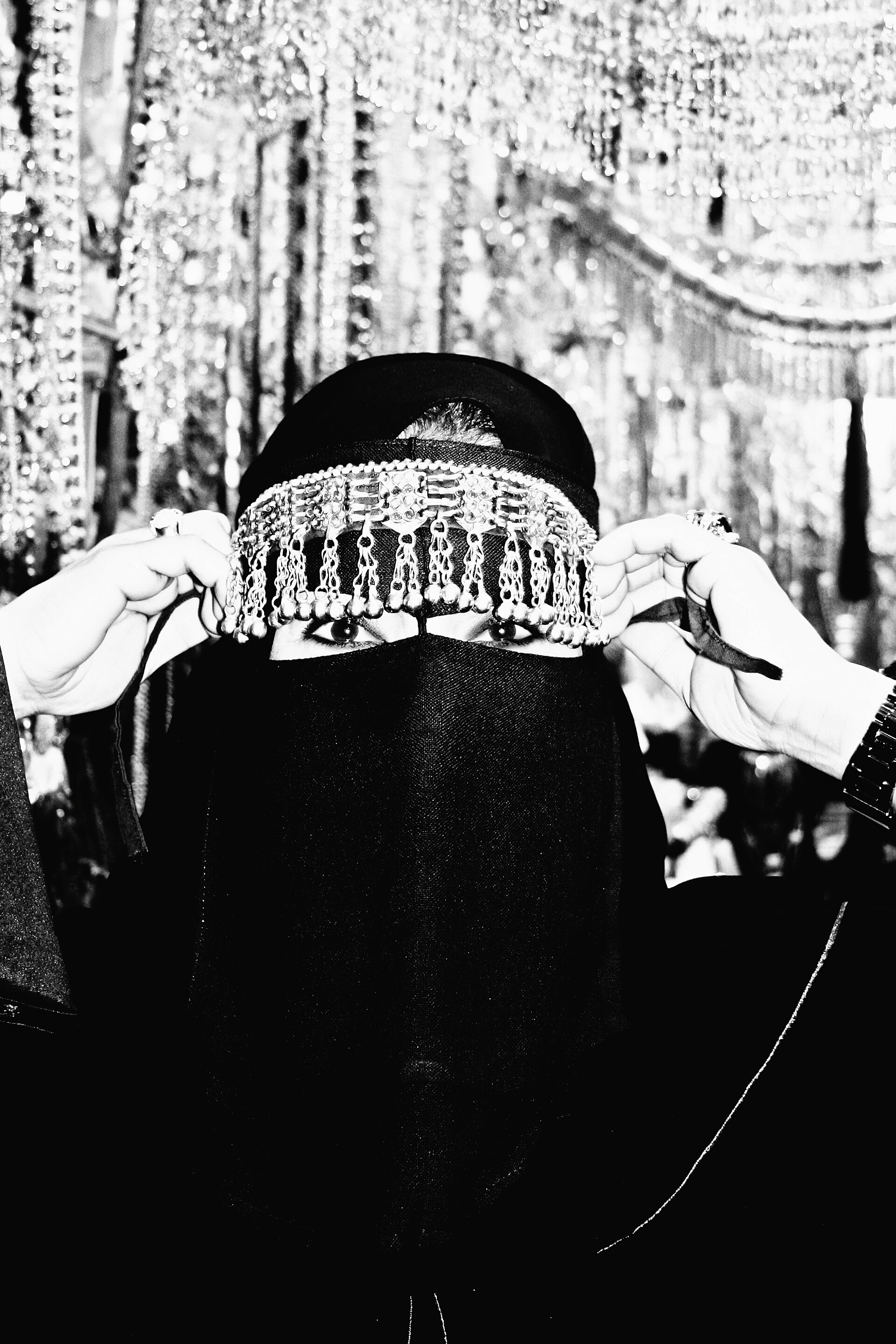Woman wearing a traditional black abaya with ornate silver headpiece in downtown Jeddah