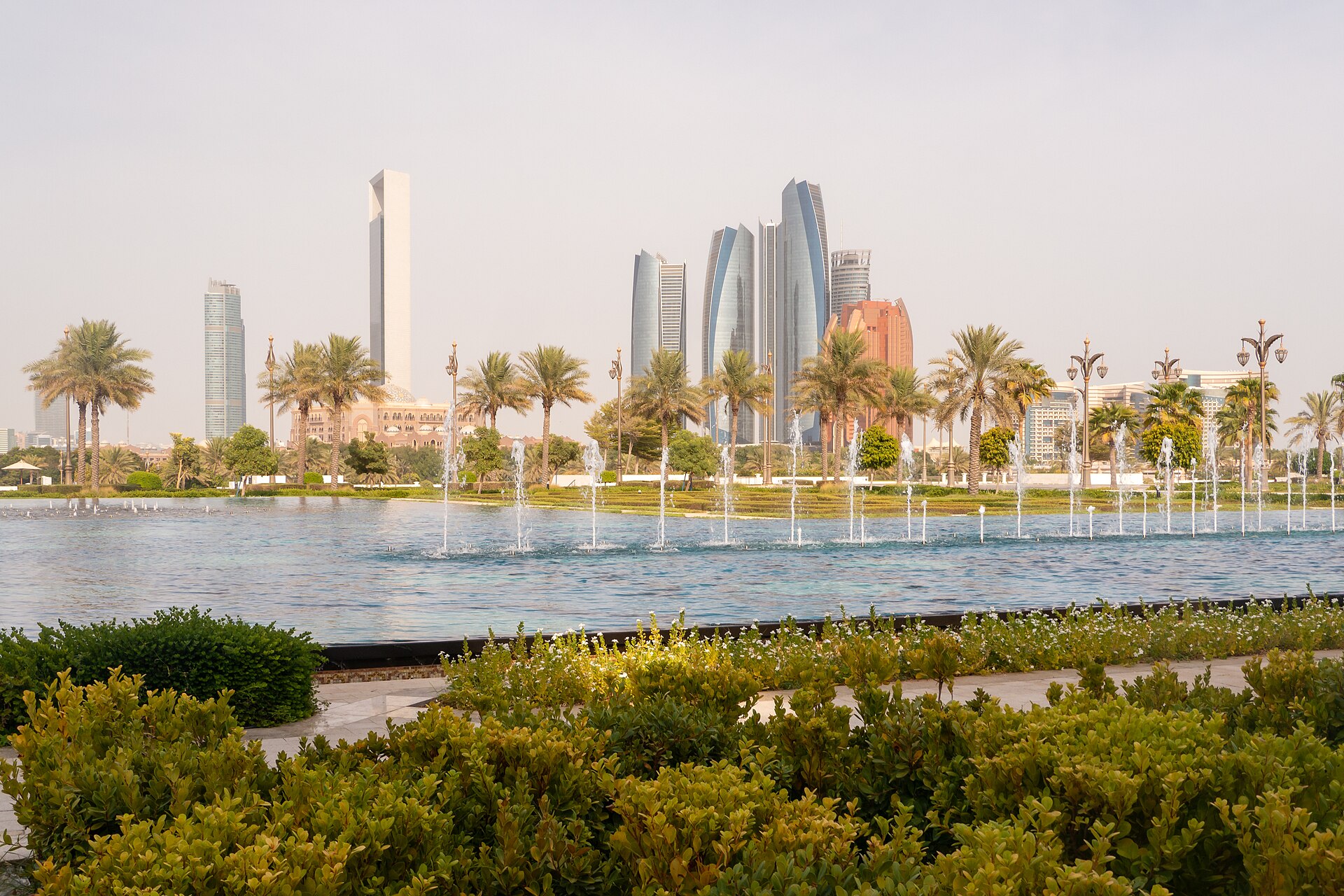 Abu Dhabi downtown skyline with Etihad towers visible from the gardens of Qasr Al Watan — the UAE capital whose president did not attend the April 2026 GCC Decisiveness Summit