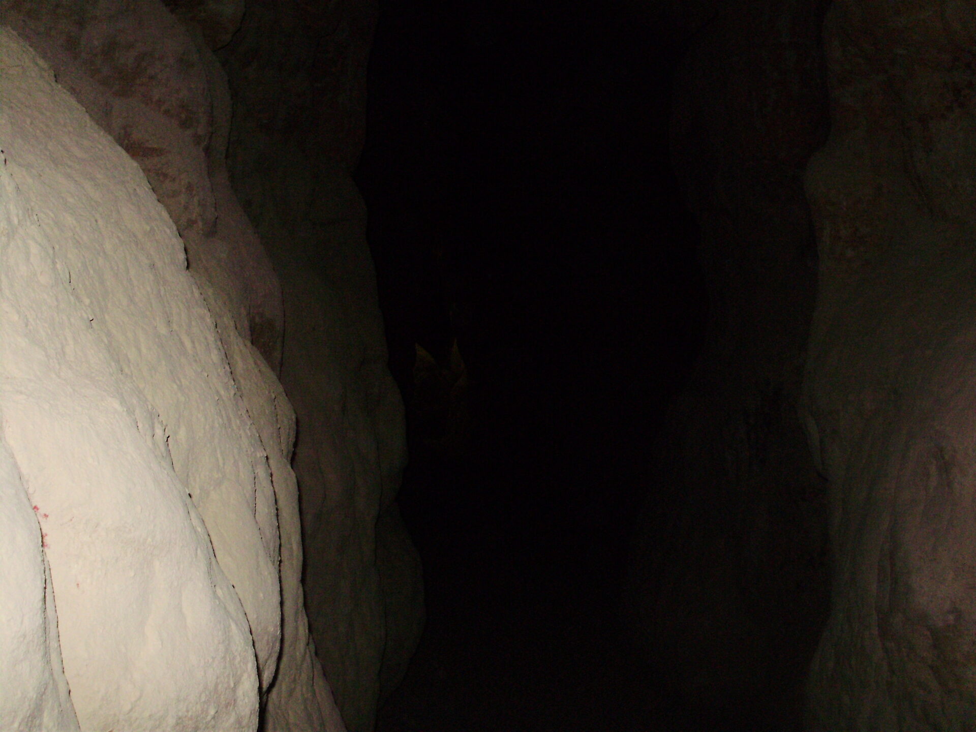 Deep passage inside Al Qarah Mountain cave system in Al Ahsa, Saudi Arabia, with natural light filtering through an opening above