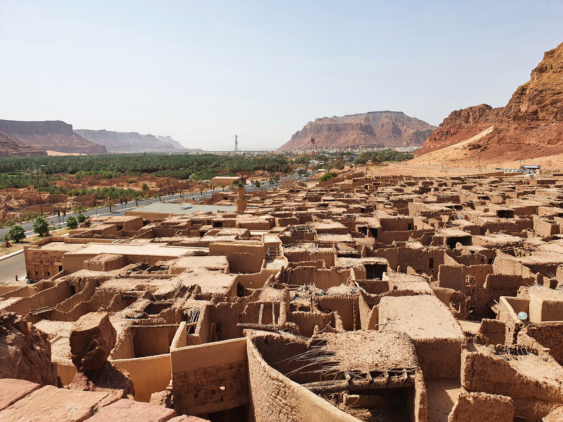 Old Town AlUla viewed from the fort, showing the historic mud-brick settlement surrounded by palm groves and sandstone cliffs