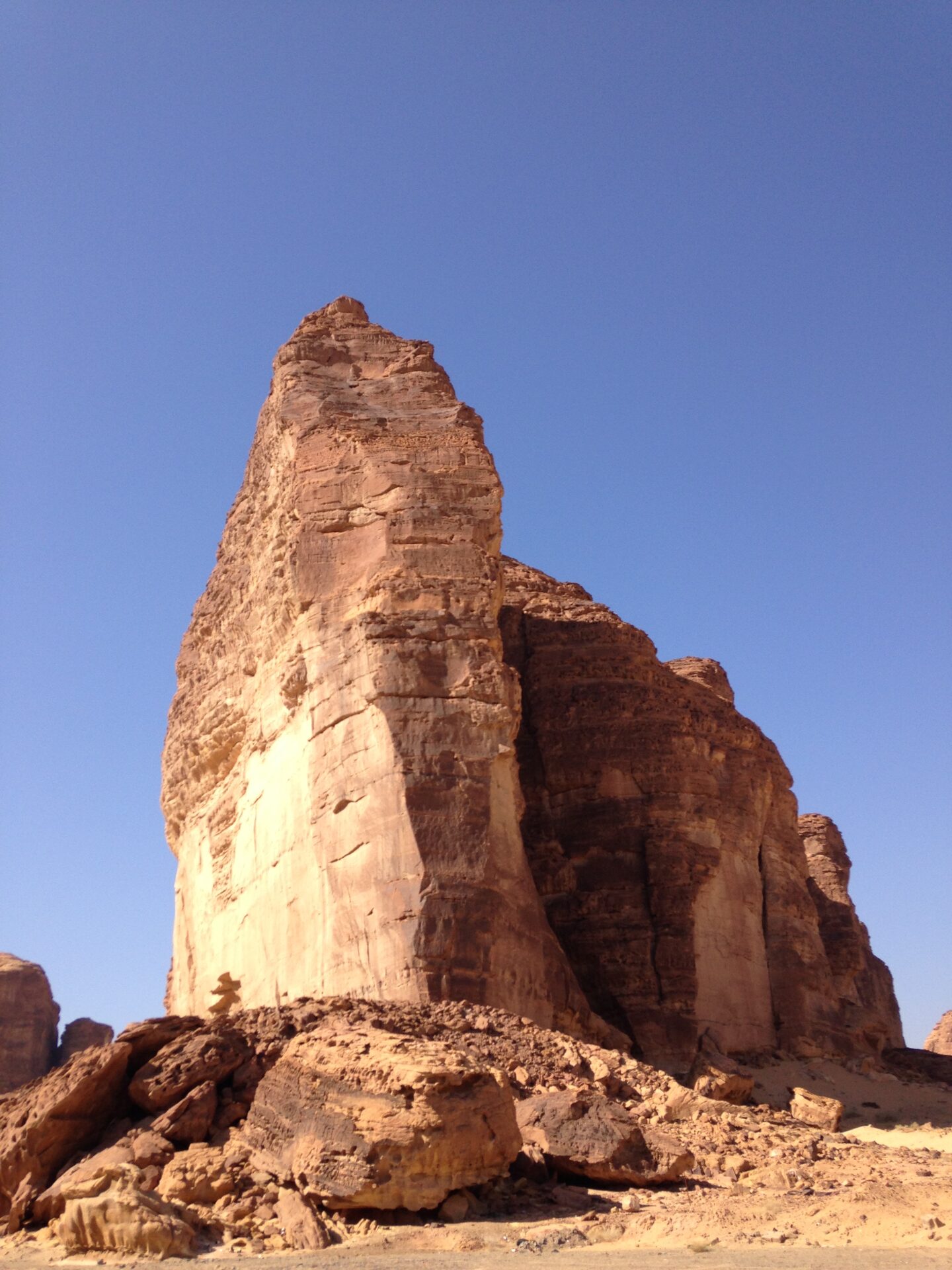 A towering sandstone rock formation near AlUla, Saudi Arabia, typical of the climbing terrain in the region