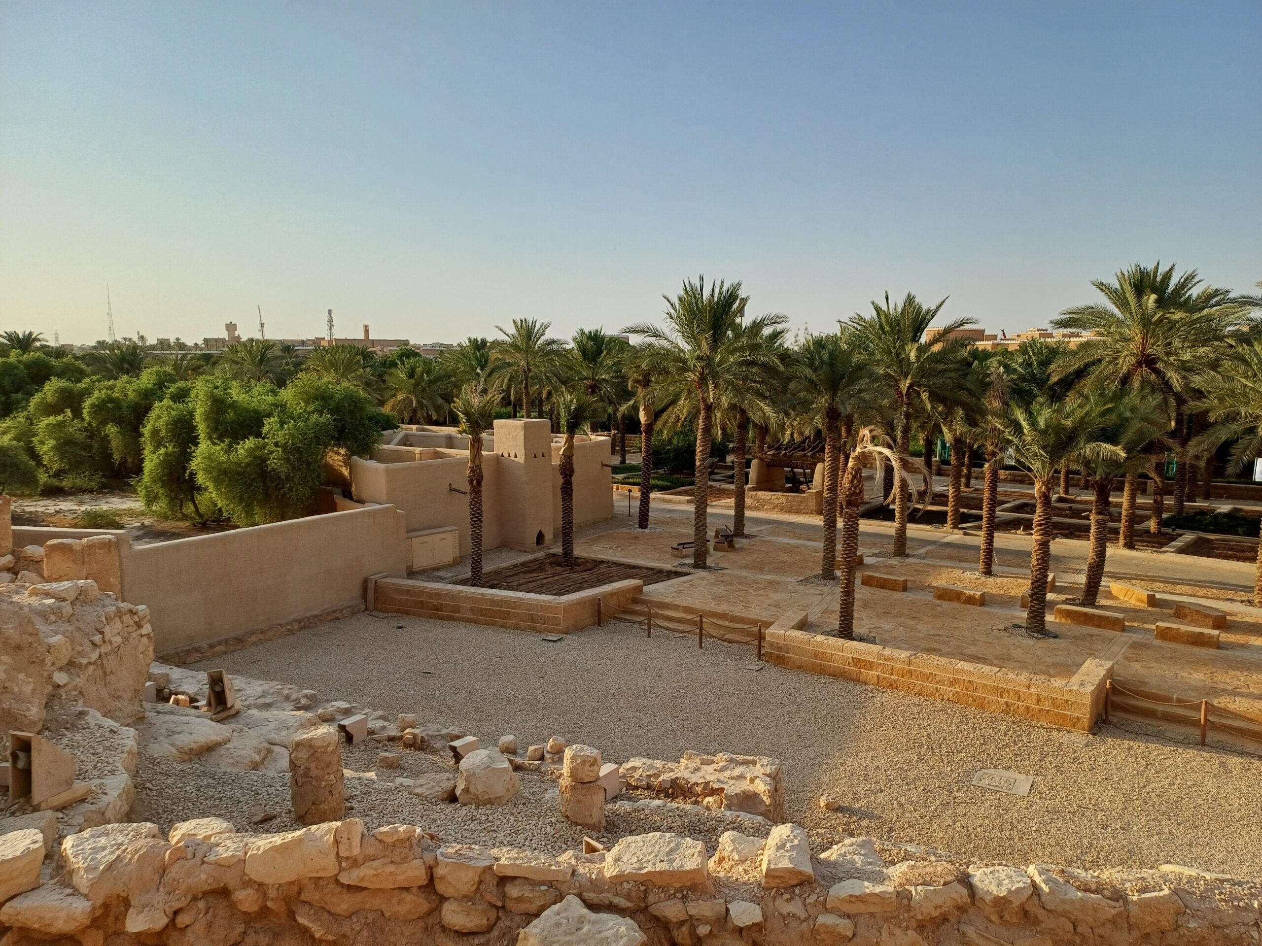 Courtyard with palm trees and archaeological remains at At-Turaif UNESCO site in Diriyah