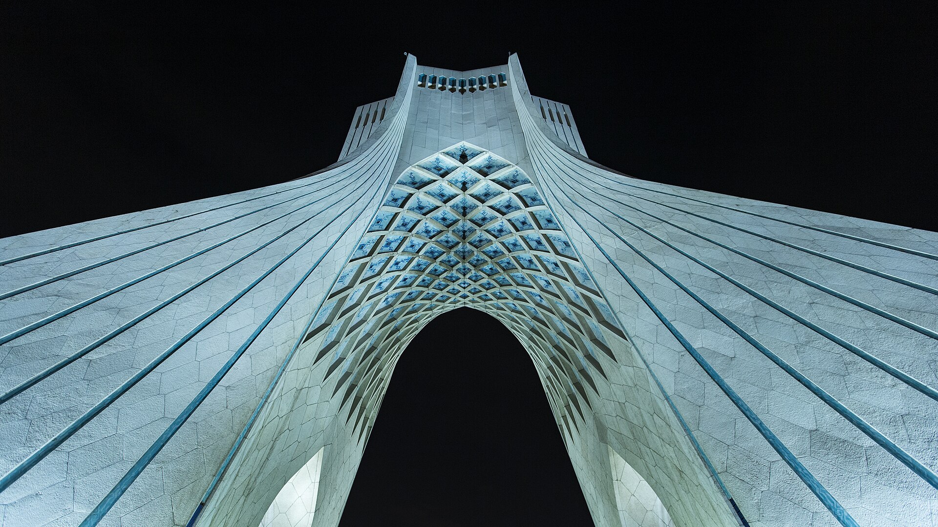 Azadi Tower in Tehran at night — the Islamic Republic capital where Ali Khamenei remains unburied 46 days after the February 28 airstrike, as his successor Mojtaba governs by audio from undisclosed Qom location