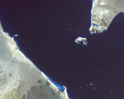 Bab el-Mandeb strait satellite image — ASTER false-colour view showing the 18-mile-wide chokepoint between Yemen (upper right) and Djibouti/Eritrea (lower left), with Perim Island visible in the channel