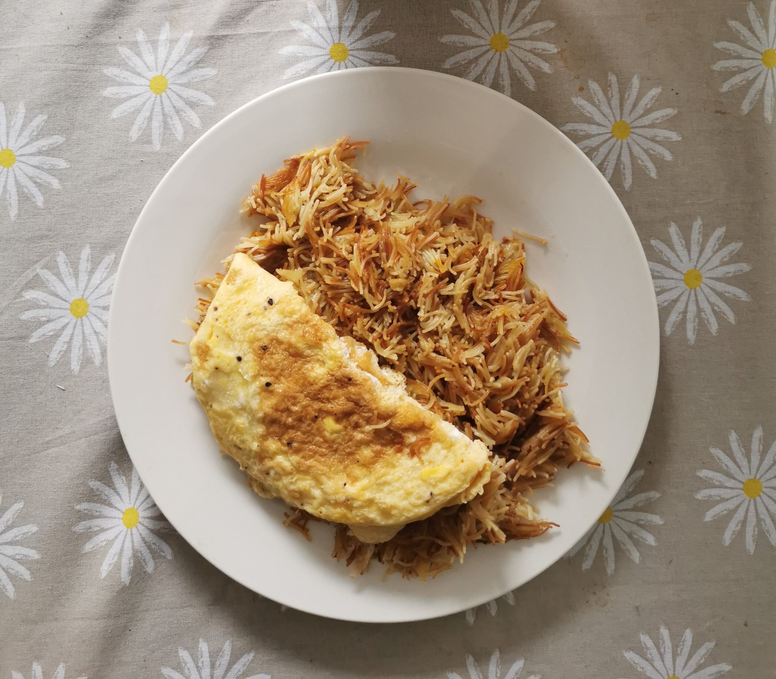 Balaleet sweet saffron vermicelli with folded omelette on a white plate
