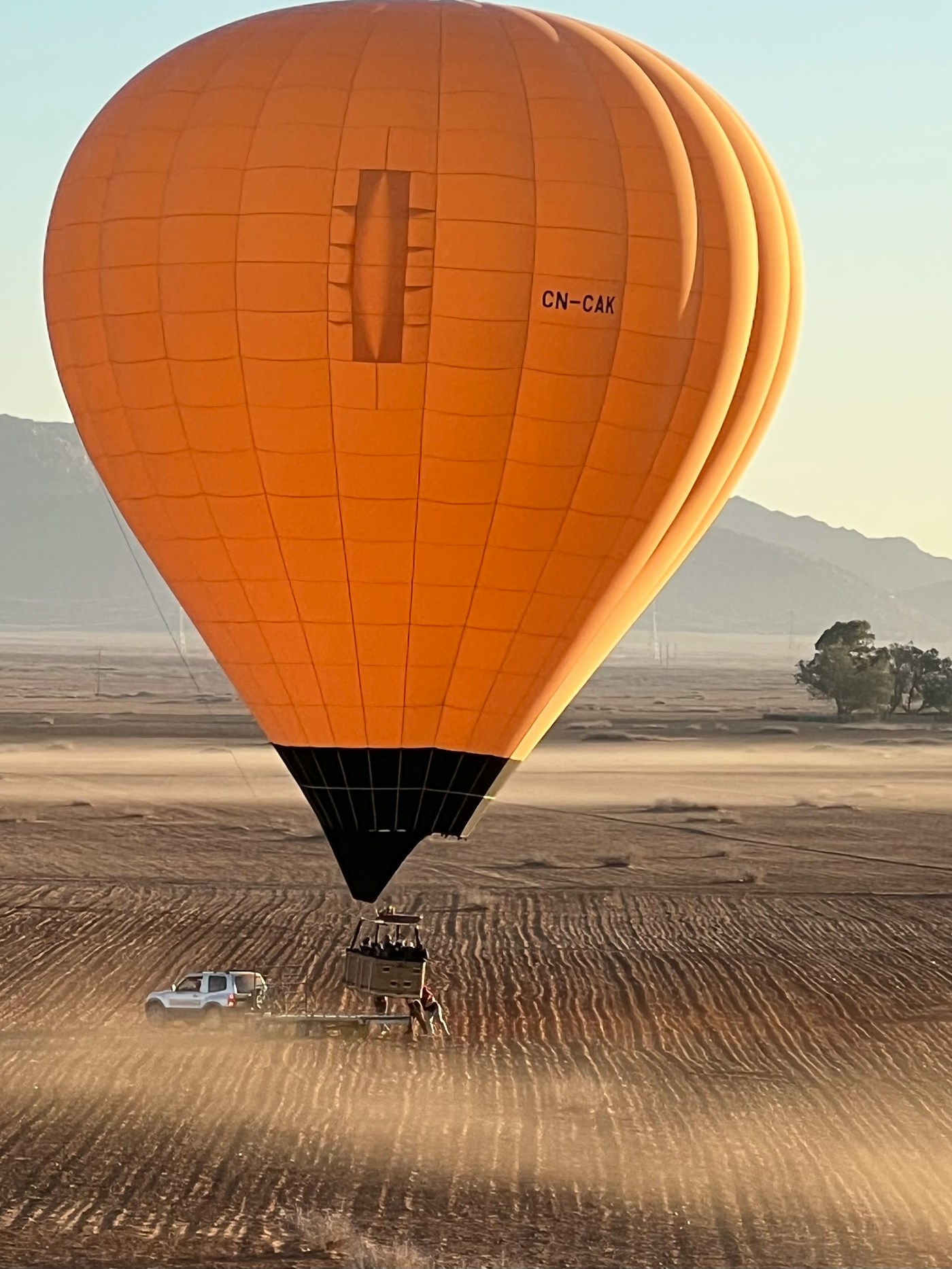 Hot air balloon being inflated on the desert floor before a sunrise flight