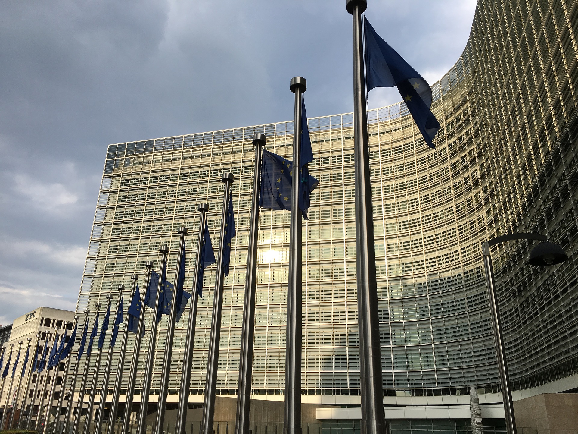 European Commission Berlaymont headquarters in Brussels with EU flags — the institutional home of the European Commission, whose president Ursula von der Leyen endorsed GCC missile and proxy conditions at the Cyprus summit