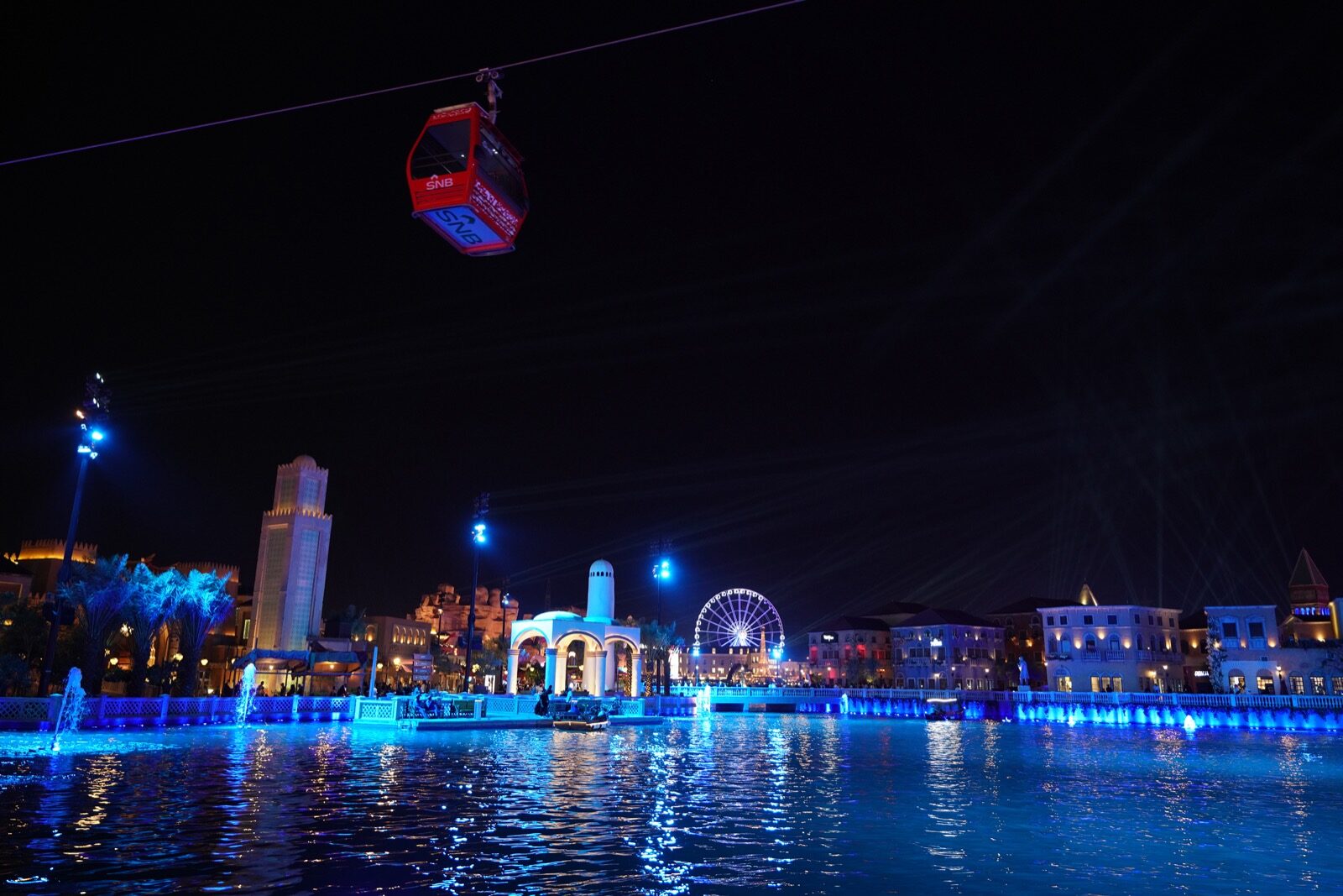 Boulevard Riyadh City entertainment zone at night with illuminated buildings, cable car, and water features