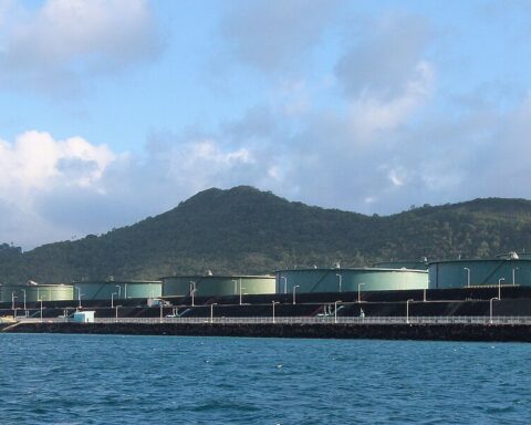 Crude oil storage terminal with tanker at berth and multiple storage tanks, showing a Red Sea-style export terminal similar to Aramco's Yanbu facility