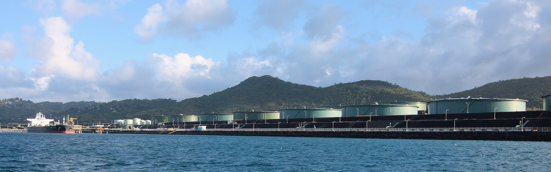 Crude oil storage terminal with tanker at berth and multiple storage tanks, showing a Red Sea-style export terminal similar to Aramco's Yanbu facility