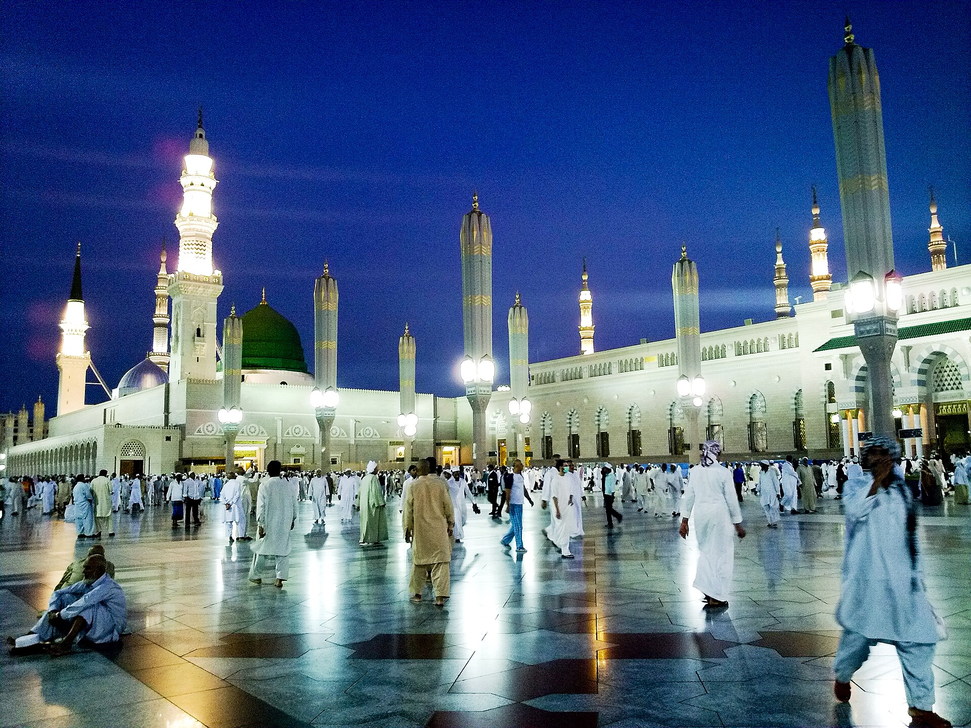 The Prophet's Mosque in Medina illuminated at twilight with its green dome and minarets