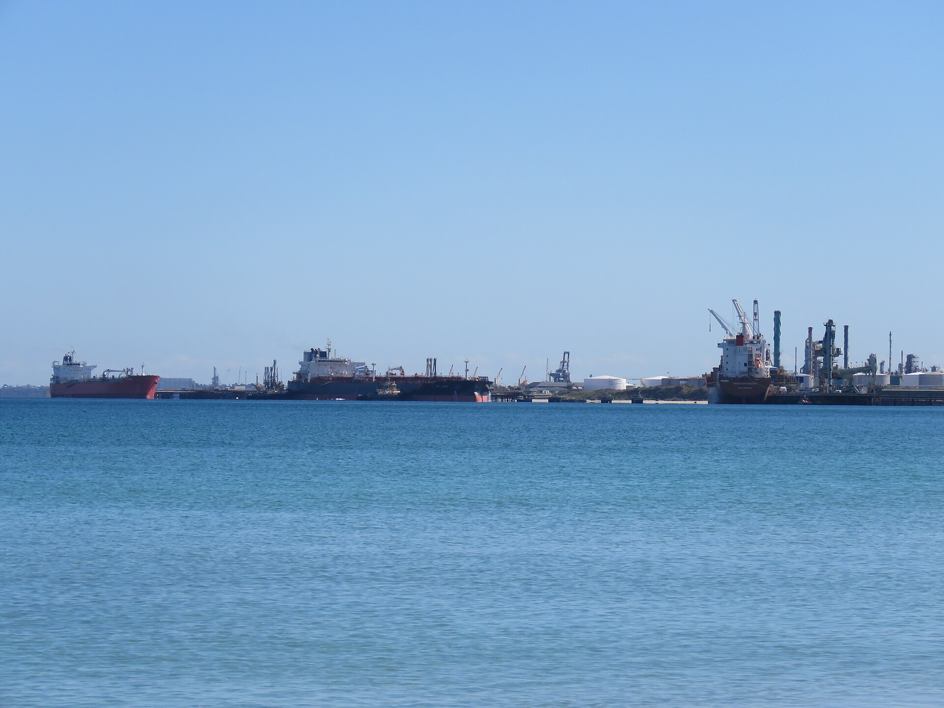 Crude oil tankers moored at oil refinery port terminal loading petroleum cargo