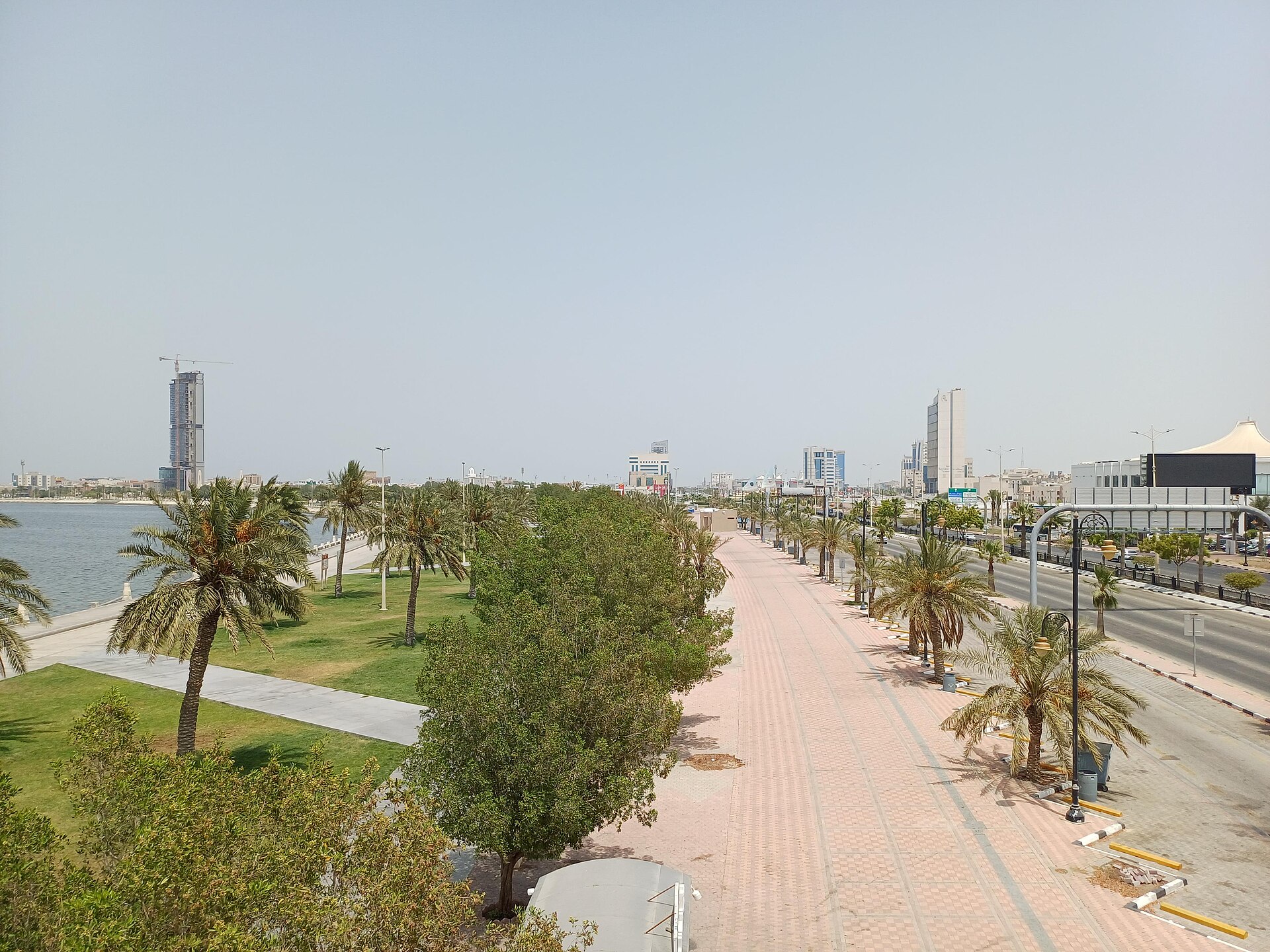Dammam Corniche waterfront promenade along the Arabian Gulf with palm trees and city skyline