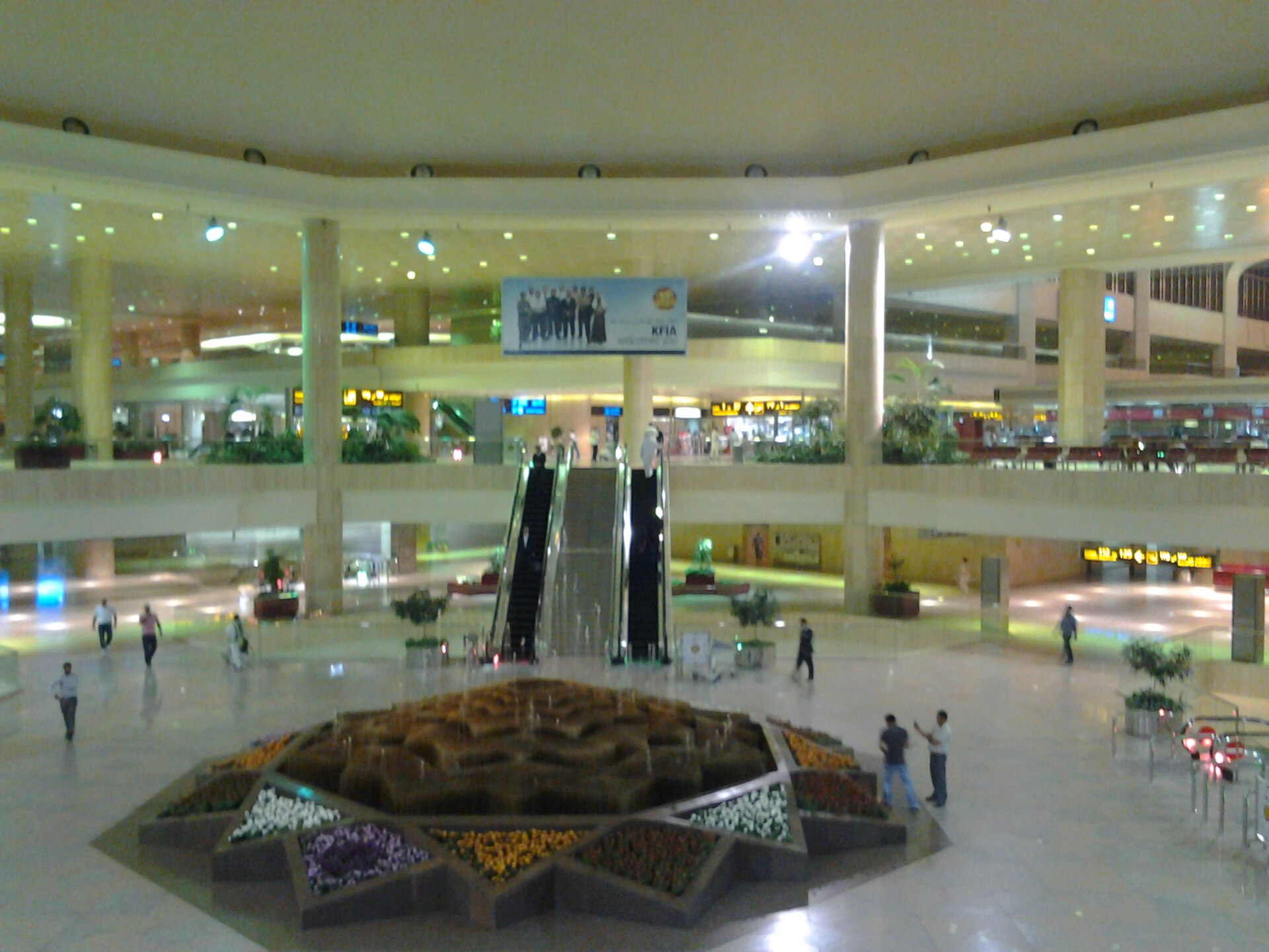 Interior of King Fahd International Airport in Dammam, Saudi Arabia, showing the main terminal atrium with escalators and geometric fountain