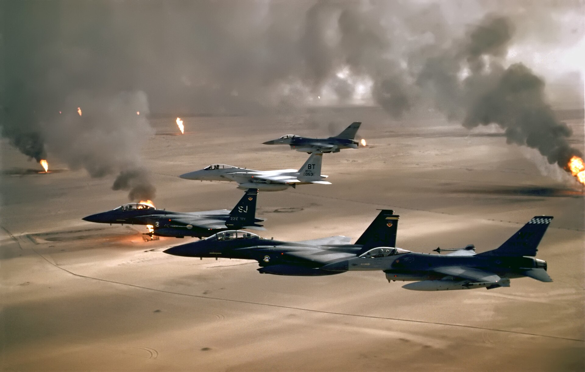 USAF F-16, F-15C and F-15E aircraft of the 4th Fighter Wing fly over burning Kuwaiti oil wells during Operation Desert Storm, 1991 — the closest historical precedent to the air campaign Trump is threatening against Iran