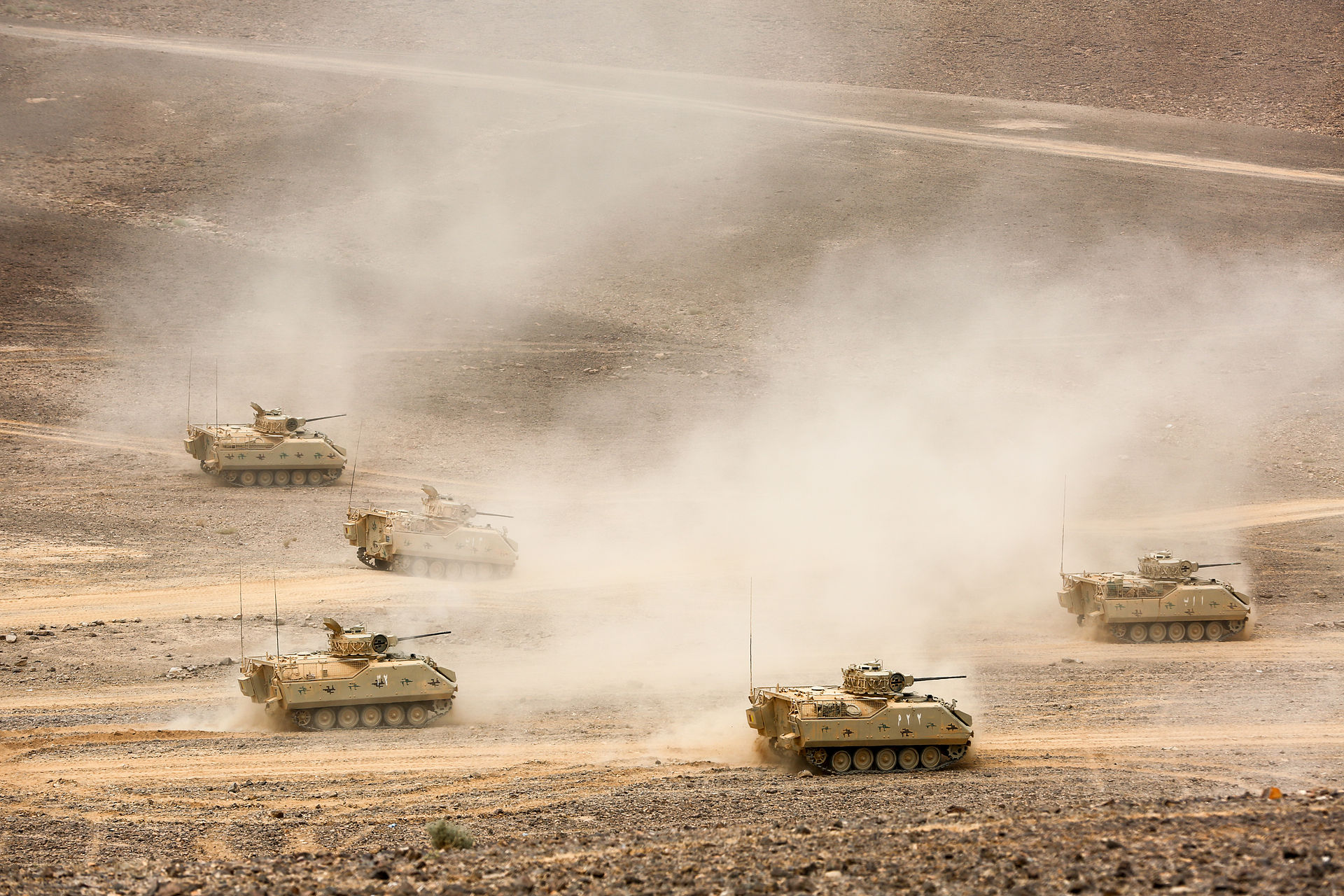Jordanian armoured tracked vehicles charge across desert terrain during Exercise Eager Lion 2015, Wadi Shadiyah, Jordan