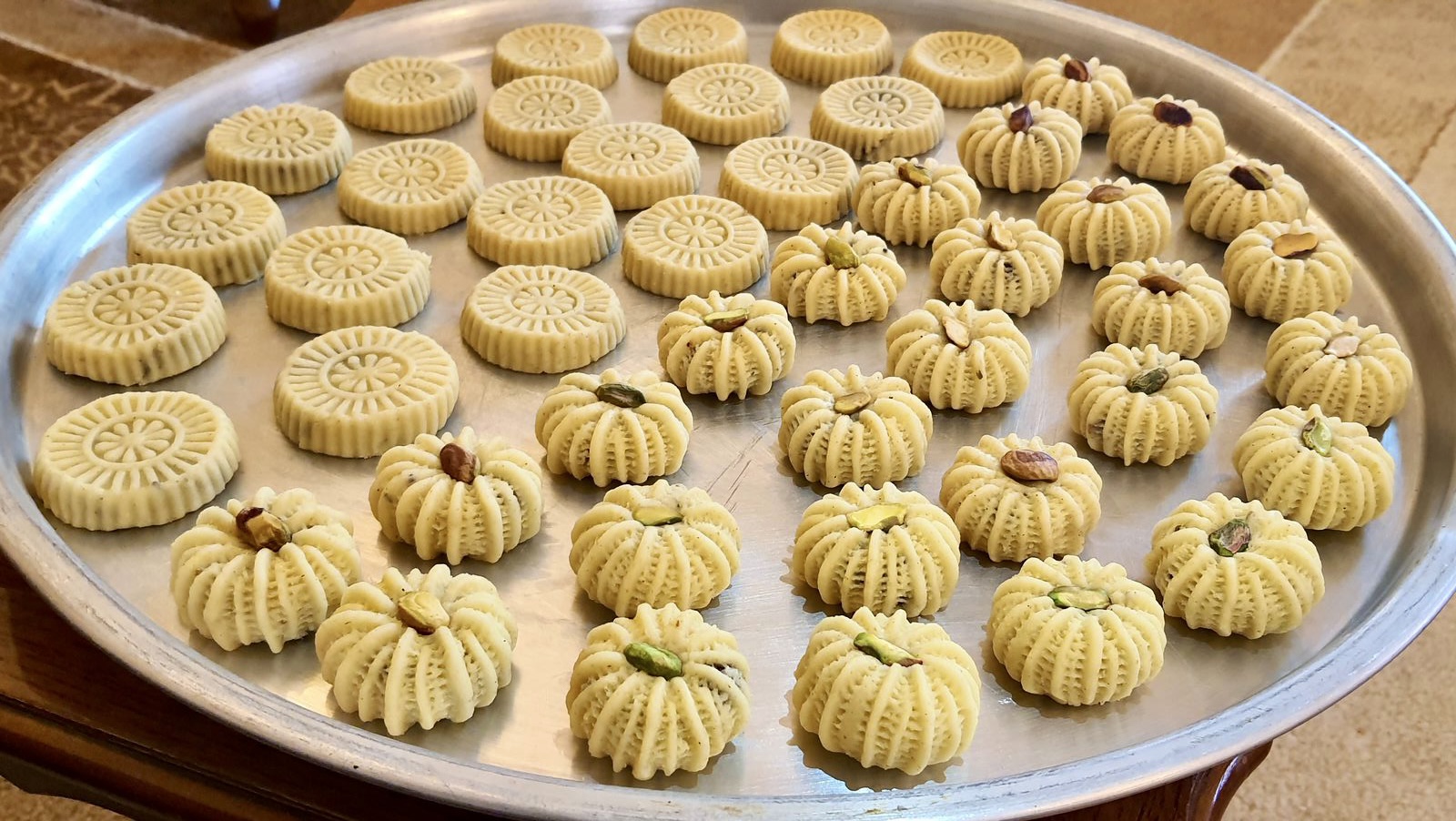 A tray of freshly made maamoul cookies in decorative pressed shapes — traditional Eid Al Fitr sweets