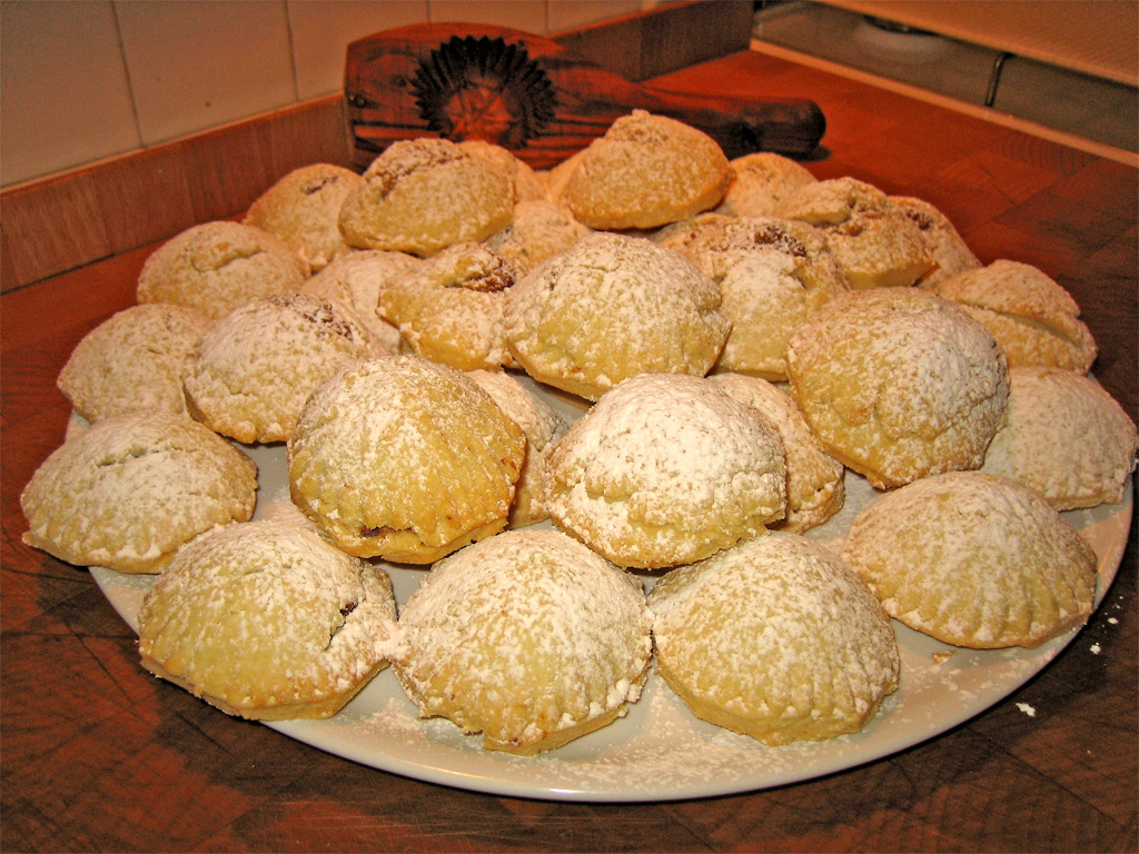 A plate of maamoul pastries dusted with powdered sugar, a traditional Eid sweet