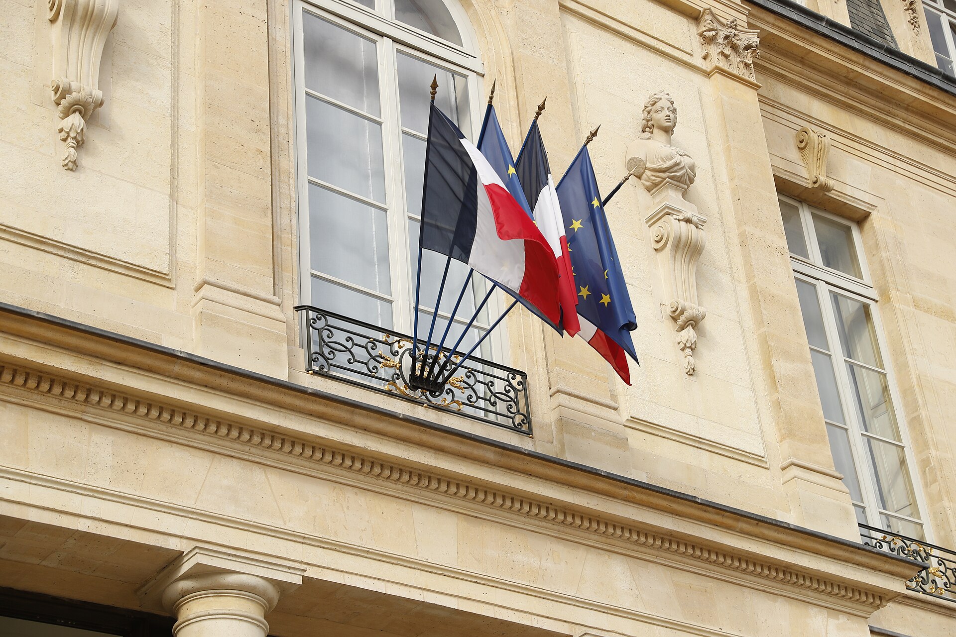 French tricolour and European Union flag flying from the Élysée Palace façade in Paris — the presidential palace hosted the 30-nation Hormuz Maritime Freedom of Navigation Initiative summit on April 17, 2026, co-chaired by Macron and Starmer