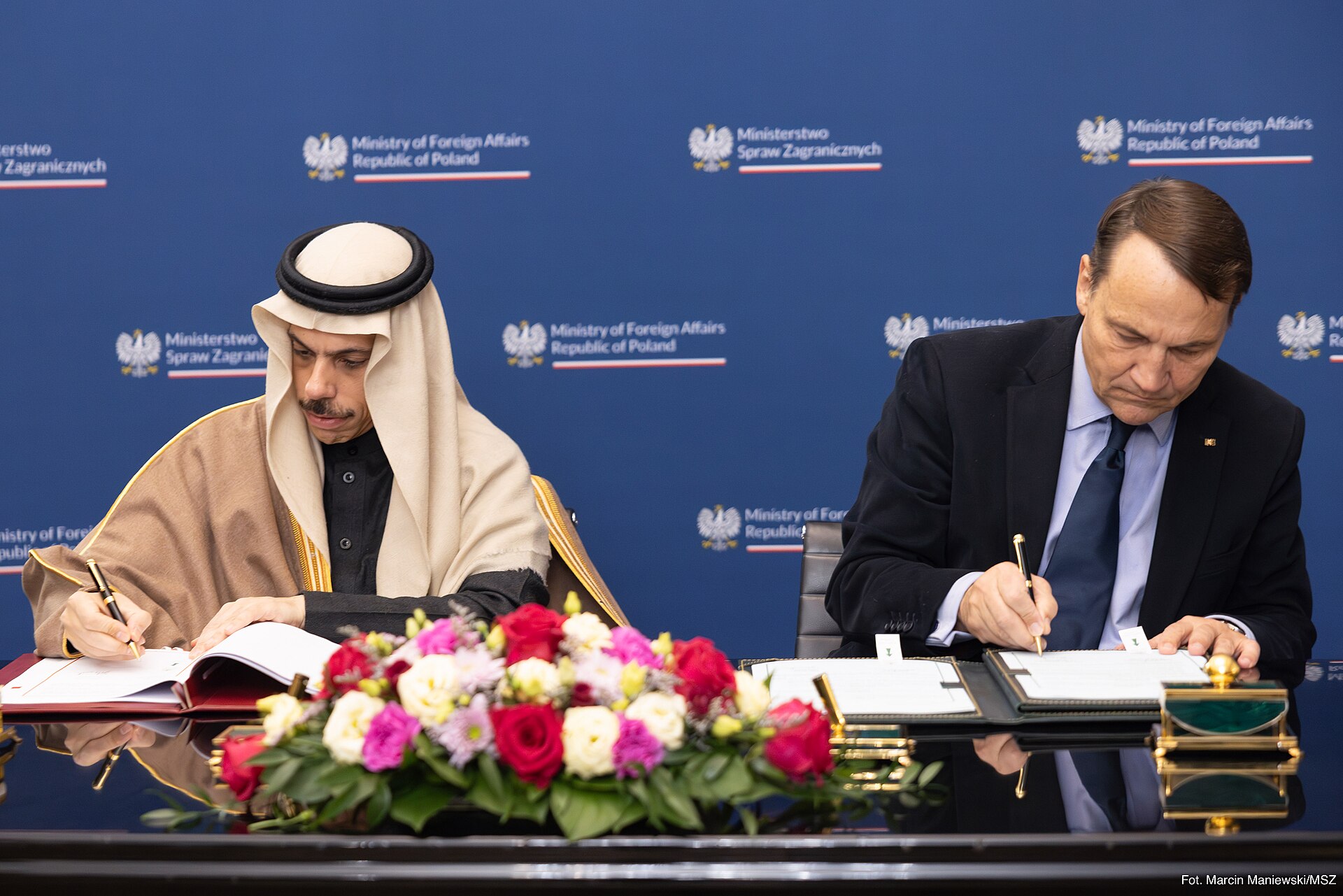 Saudi Foreign Minister Prince Faisal bin Farhan signing documents at a bilateral diplomatic meeting, Ministry of Foreign Affairs of Poland