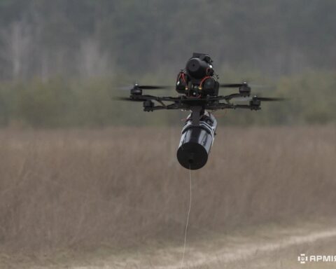 Fiber-optic guided FPV drone in flight with cable spool and trailing fiber-optic wire visible — Ukraine, 2025