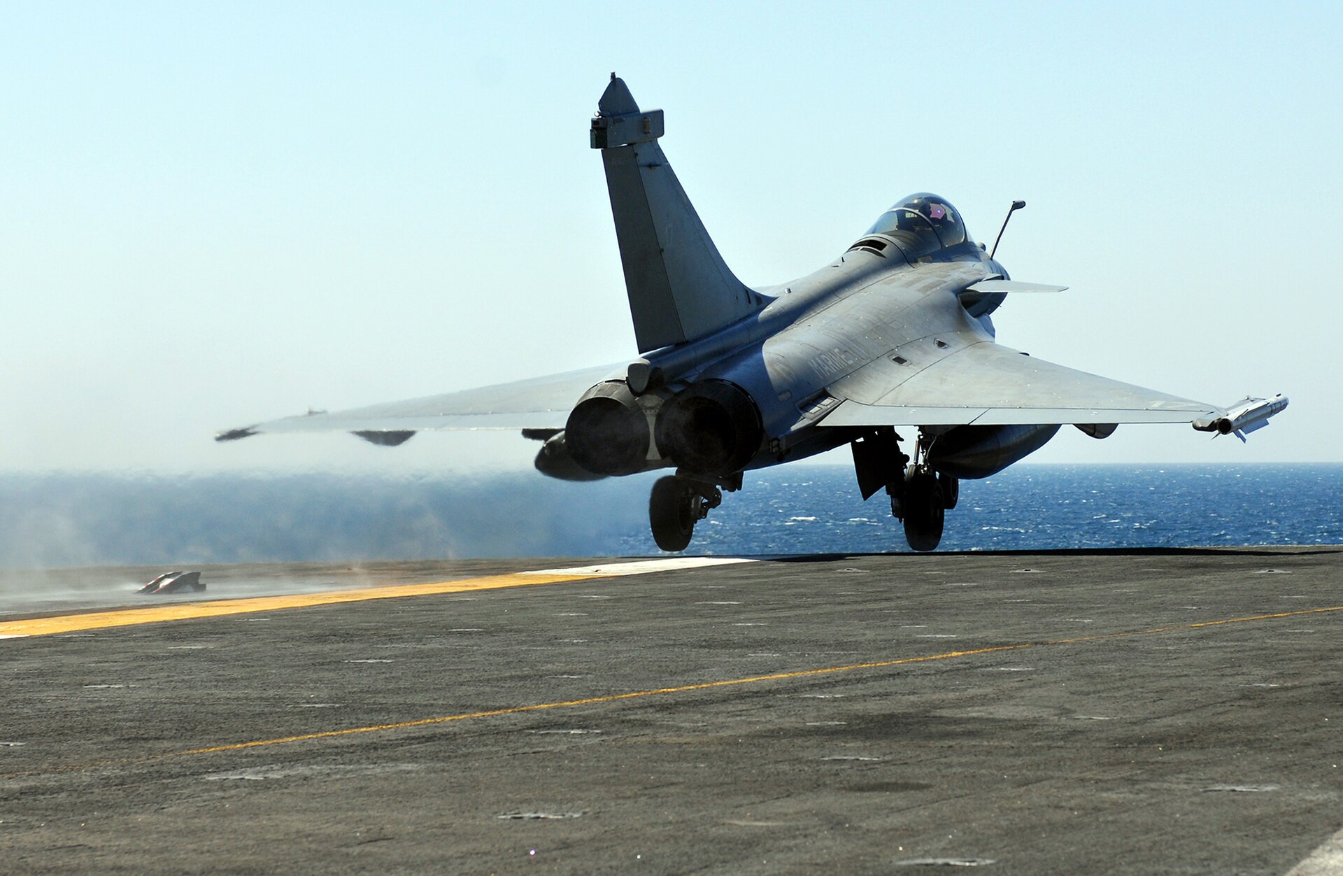 A French Navy Rafale M fighter launches from a carrier flight deck — the Paris Hormuz coalition deploying Charles de Gaulle carrier with 20 Rafale multirole fighters for potential Strait of Hormuz escort operations
