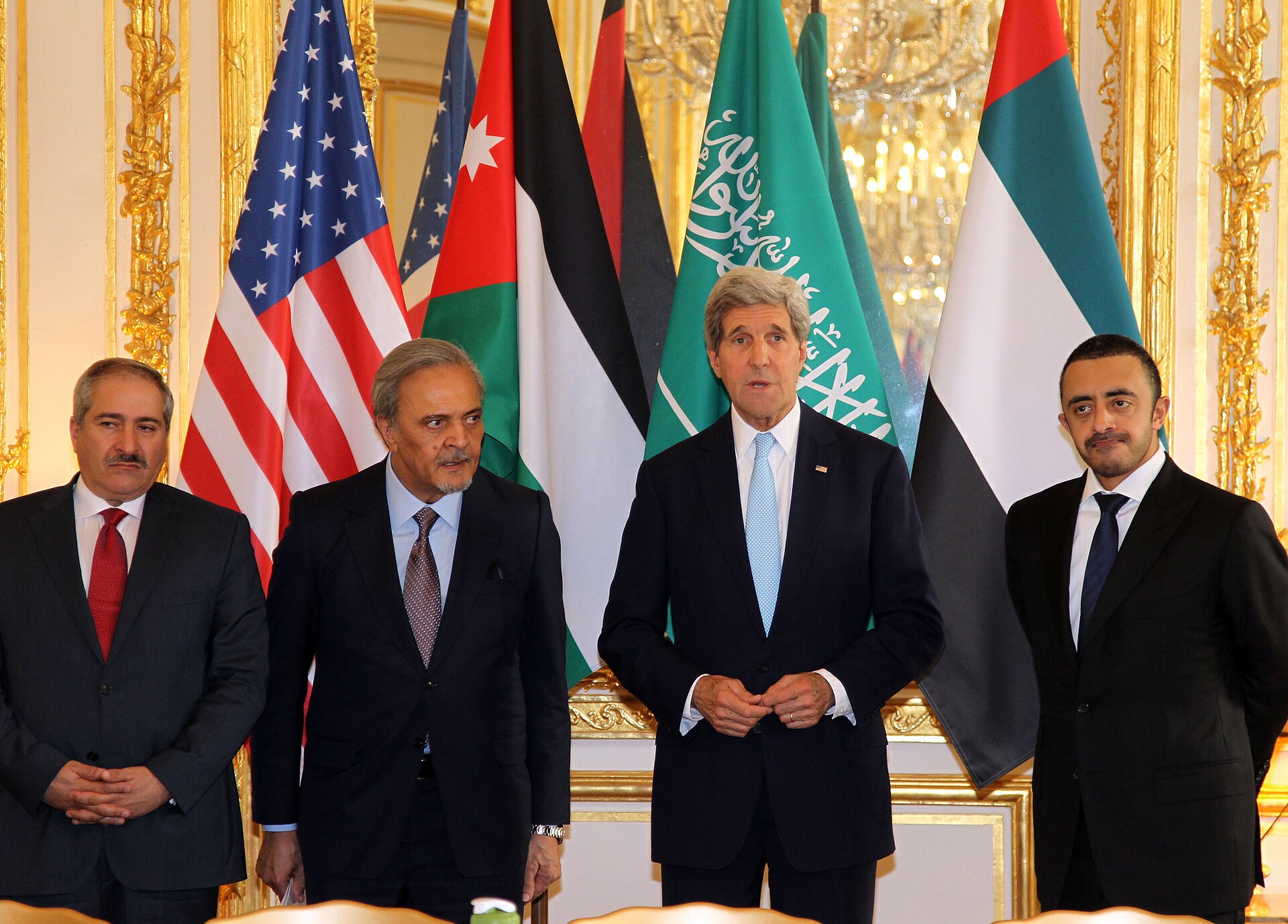 Saudi Arabia and UAE foreign ministers with Secretary Kerry and Jordan FM at multilateral meeting, June 2014, flags of Saudi Arabia and UAE prominently displayed