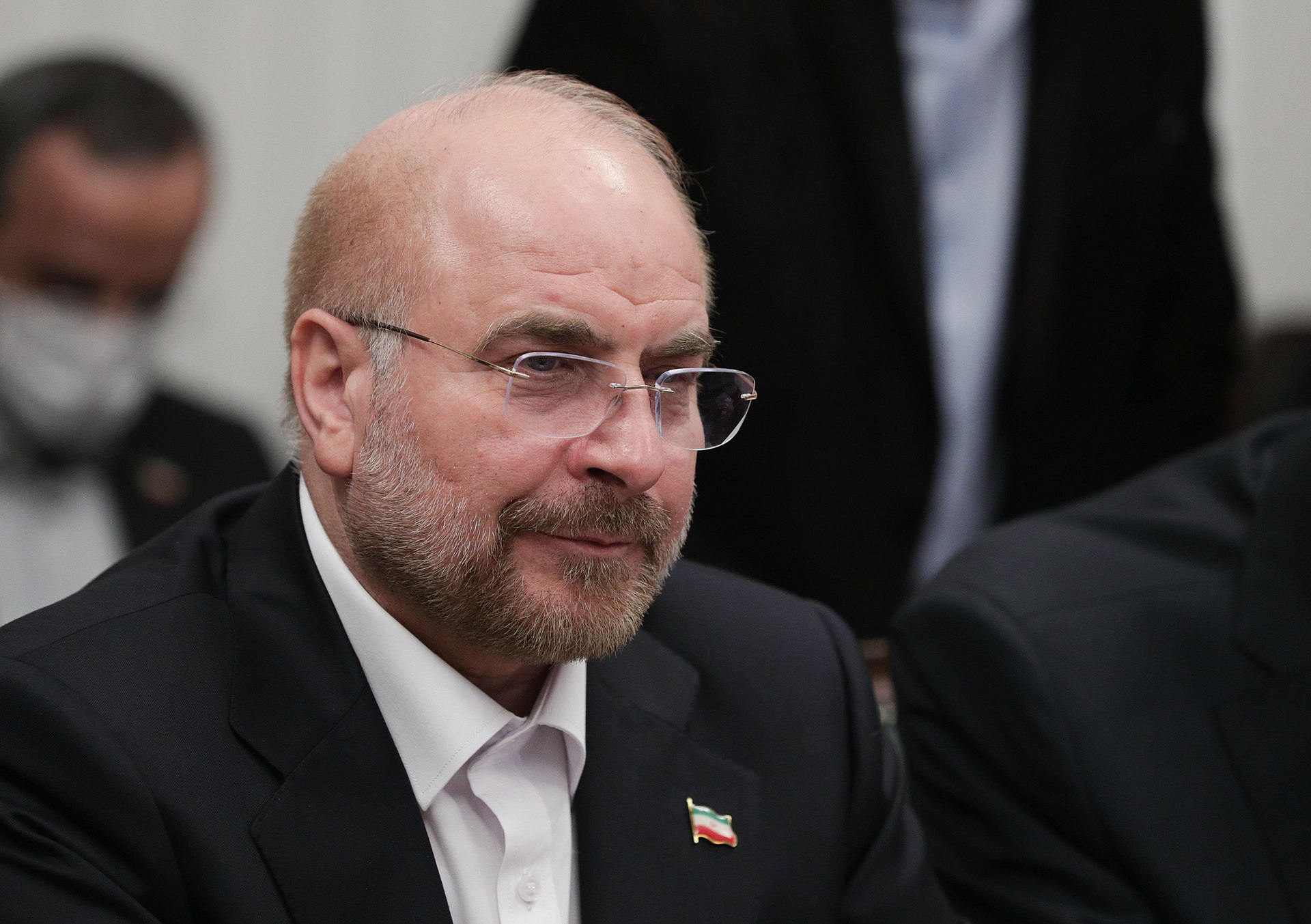 Mohammad Bagher Ghalibaf at a formal bilateral meeting wearing Iranian flag lapel pin — the Parliament Speaker commanded IRGC Aerospace Force 1997–2000