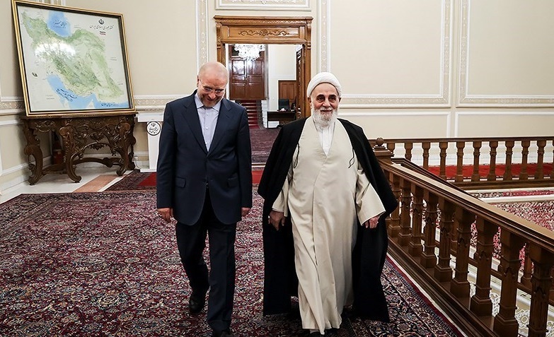 Mohammad Baqer Ghalibaf in a formal meeting at the Iranian parliament building, with a map of Iran visible on the wall behind him