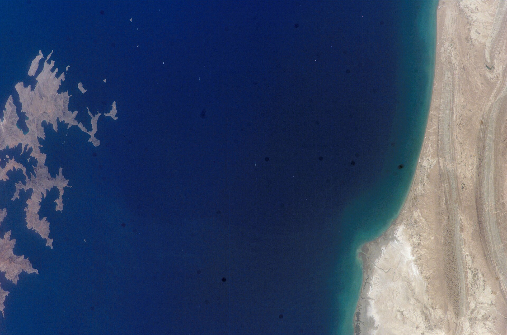 The Omani coast and Gulf of Oman photographed from the International Space Station, ISS Expedition 15, 2007. The narrow waterway visible is the strategic corridor through which tanker traffic transiting the Strait of Hormuz must pass. Zero tanker transits were recorded through Hormuz on April 4, 2026. Oman held the US-Iran mediation franchise for three decades before Iranian proximity pressure ended that infrastructure in early 2026. Photo: NASA / Public Domain