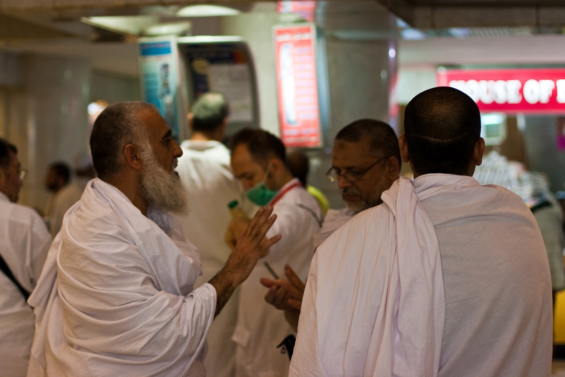 Hajj pilgrims in white ihram garments at a transit point in Saudi Arabia during the 2026 pilgrimage season