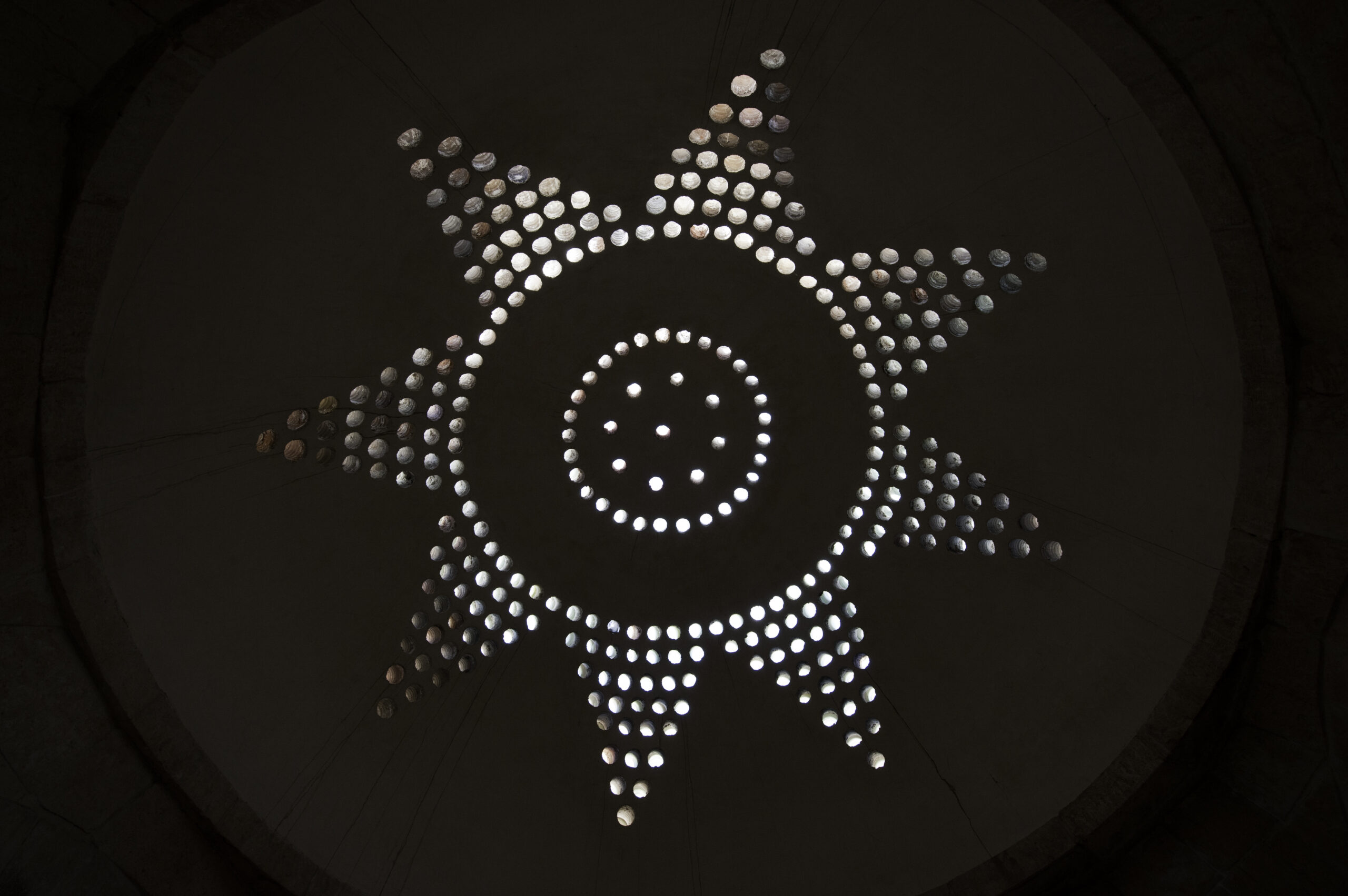 Vaulted stone interior of a medieval hammam showing light openings in the domed ceiling