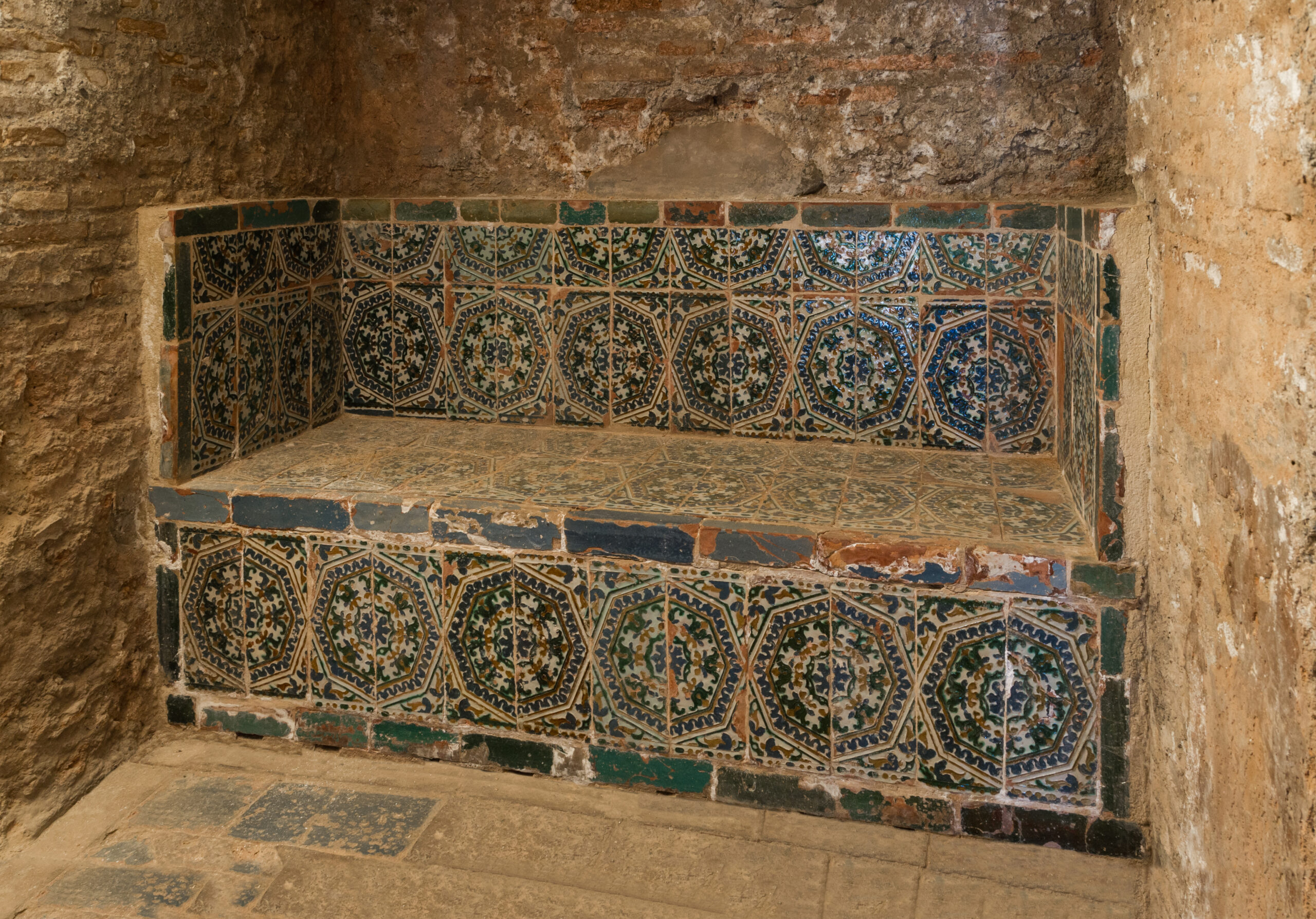 Tiled benches inside a historic hammam showing intricate Islamic geometric patterns