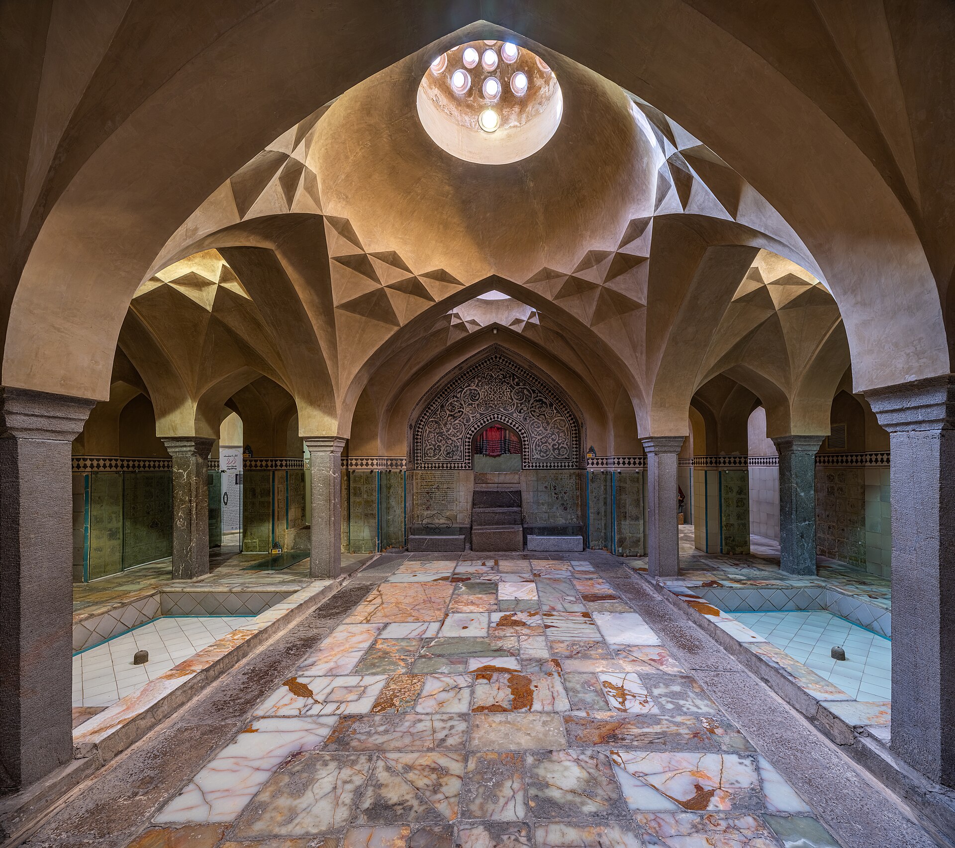 Ornate domed ceiling of a traditional hammam showing geometric vaulting and skylights