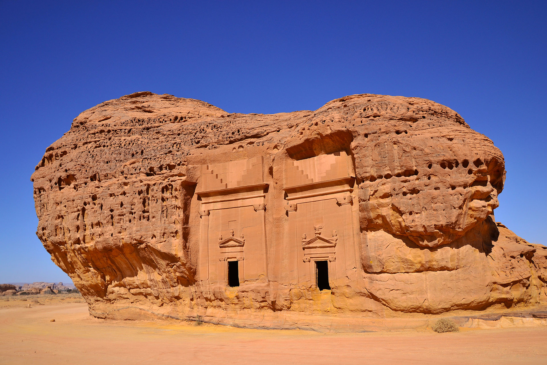 Ancient Nabataean tomb facades carved into sandstone rock formation at Hegra archaeological site near AlUla Saudi Arabia