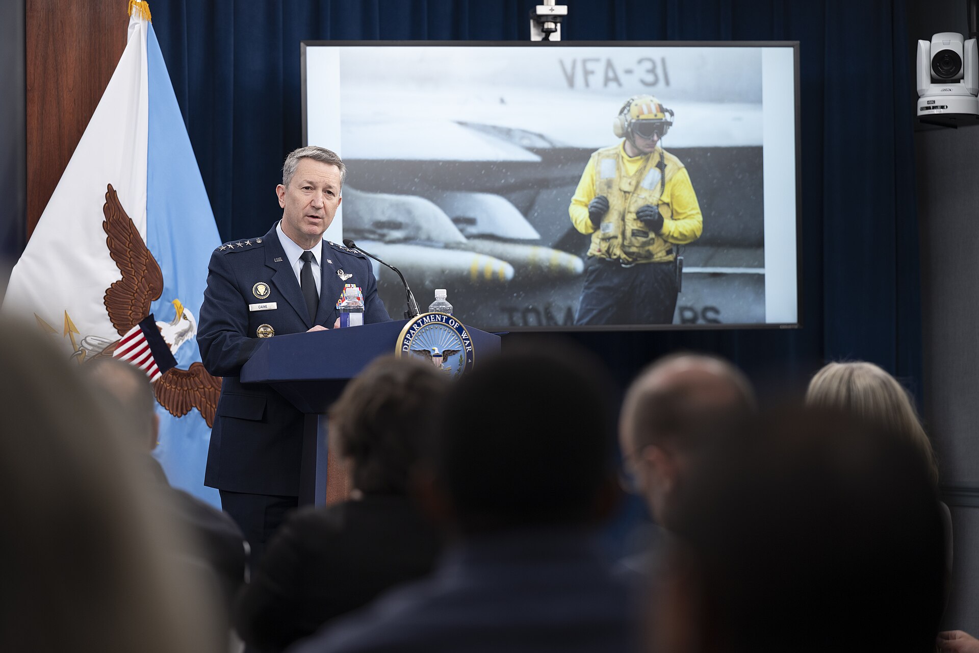 CJCS General Dan Caine at Pentagon Operation Epic Fury briefing podium with Department of War seal, April 8 2026