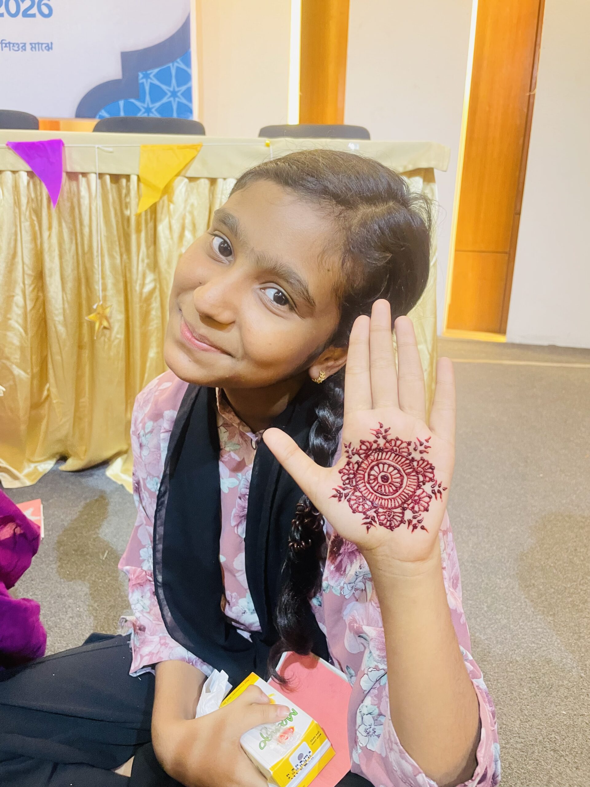 Girl showing intricate henna mandala design on her palm before Eid celebration