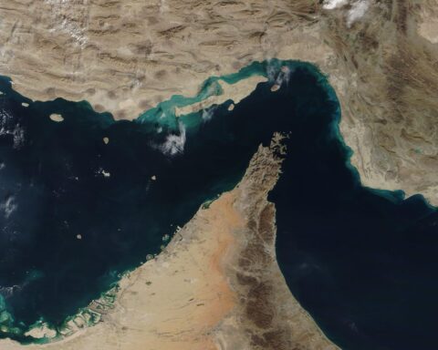 NASA MODIS satellite image of the Strait of Hormuz, December 2020, showing the 33-kilometre-wide chokepoint between Iran and Oman through which 20 million barrels per day of oil flowed before the war