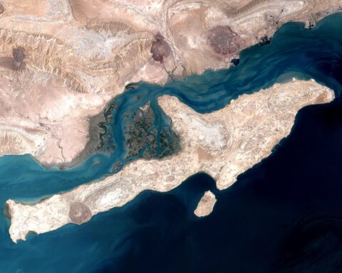 Satellite view of Qeshm Island in the Strait of Hormuz, Iran — the narrow waterway through which 20% of global oil supply transits daily
